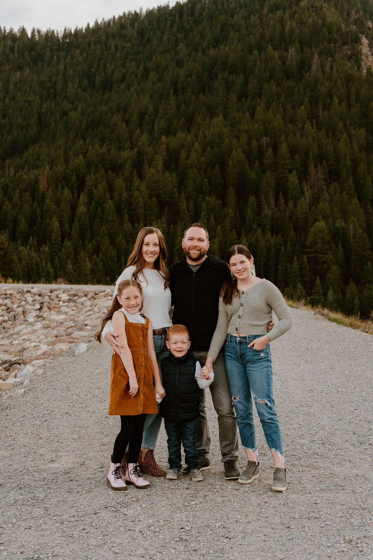 Family of five standing together in scenic Utah mountains during family session