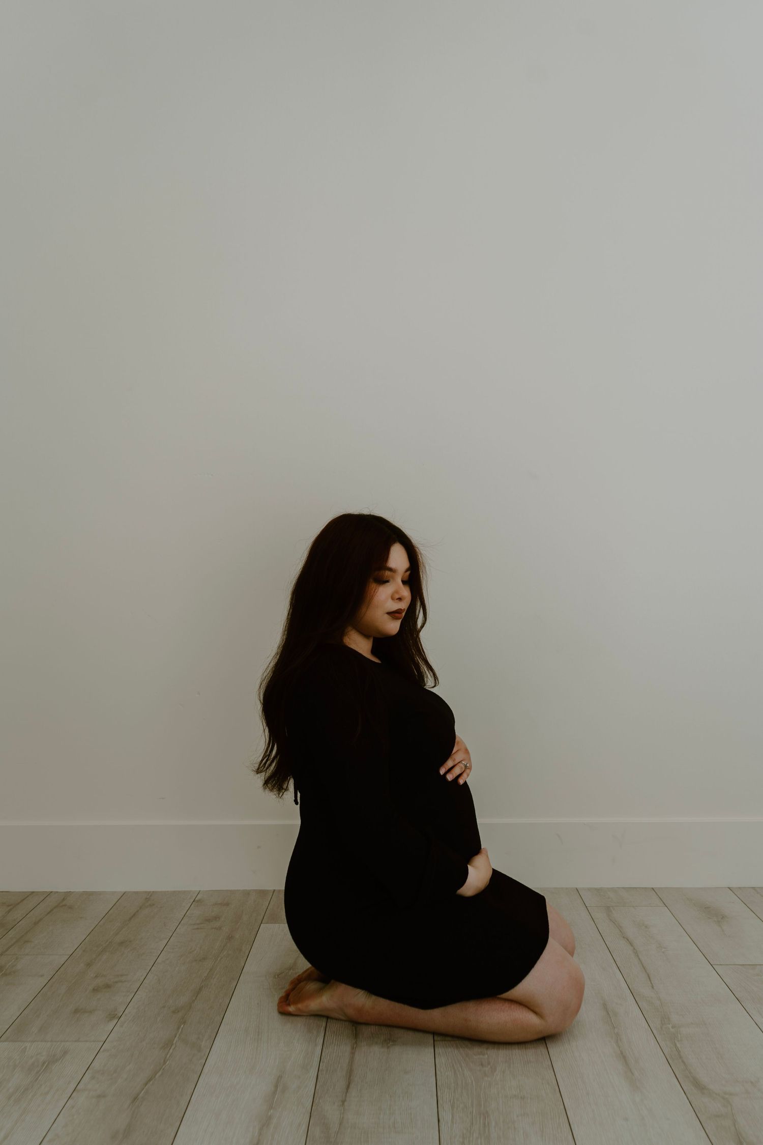 Expecting mother gently holding her belly during candid maternity photos