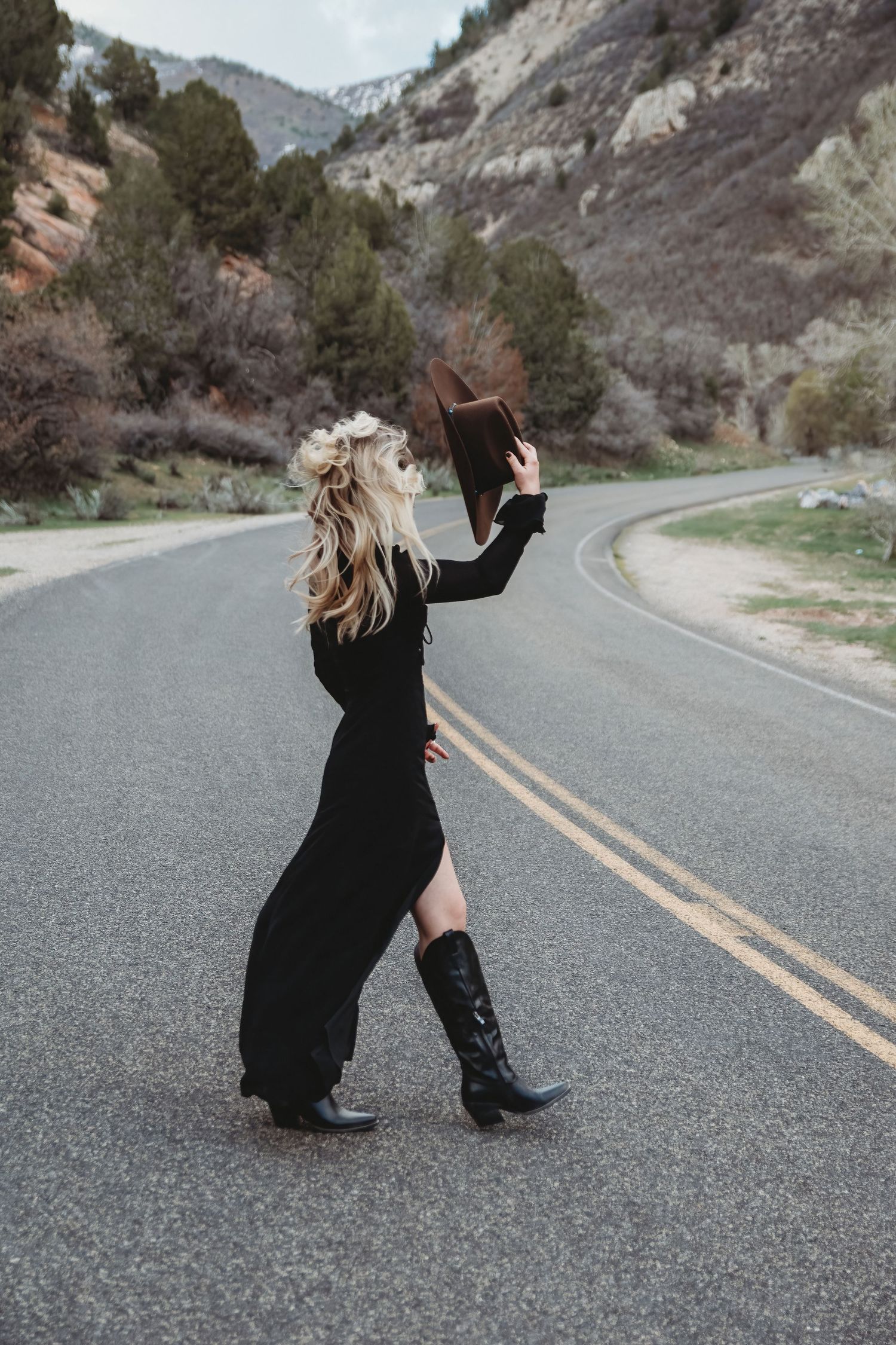 Woman walking on mountain road during stylish Utah portrait session
