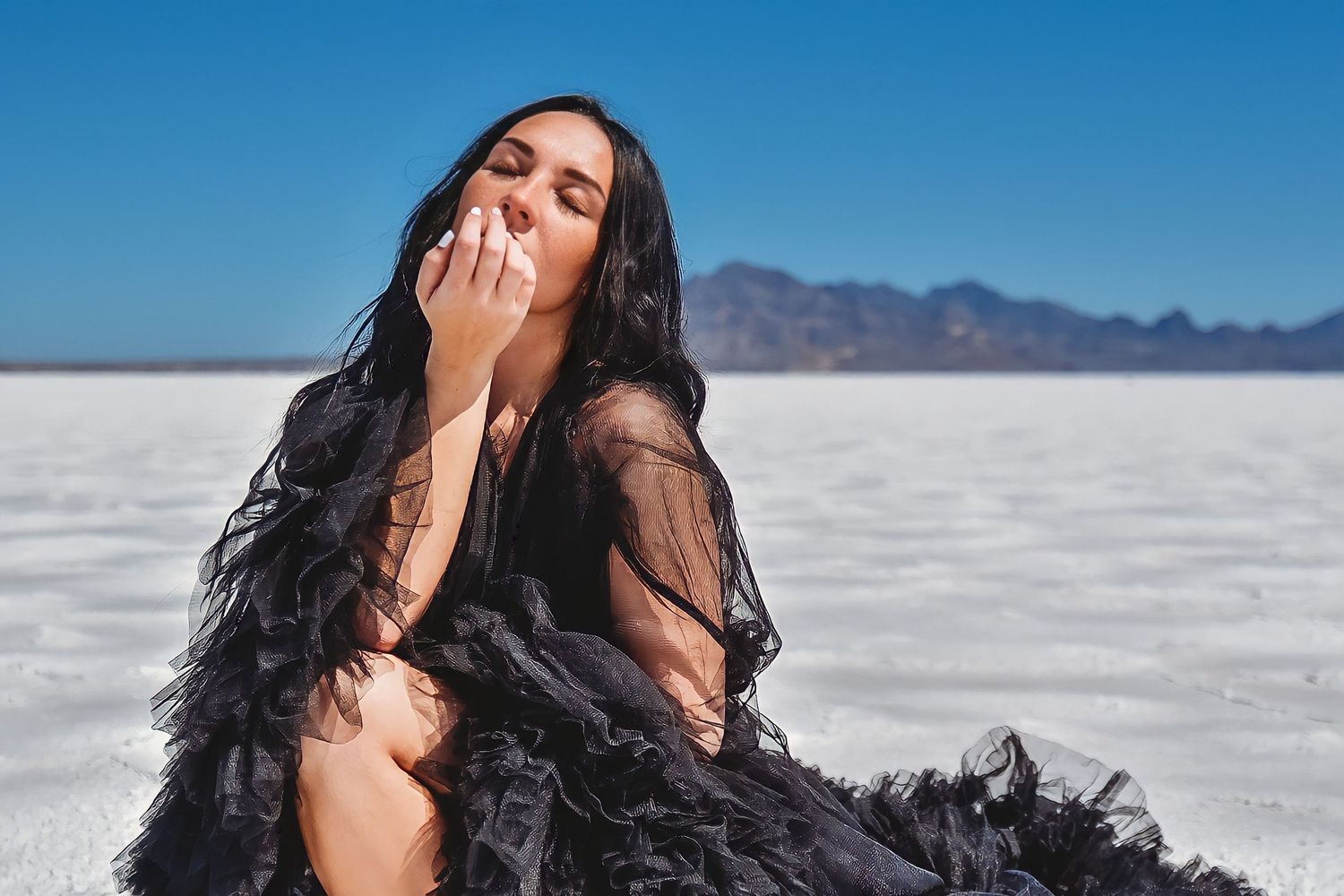 Woman in black dress posing at Bonneville Salt Flats during fashion portrait session