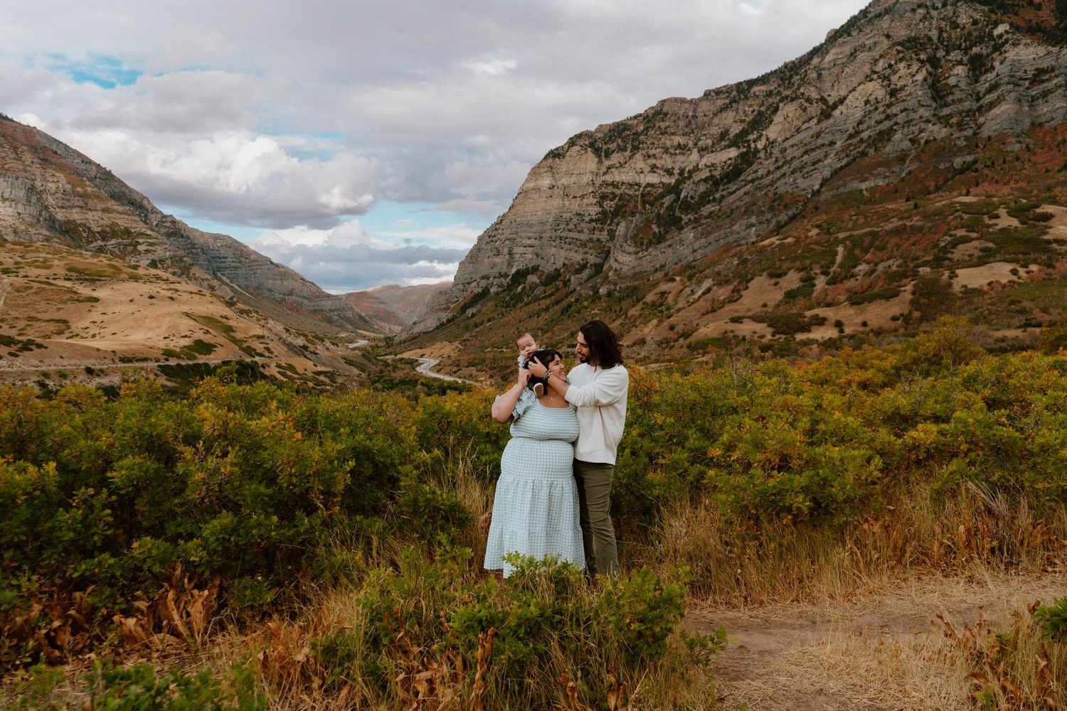 Couple embracing in scenic Utah mountain valley during fall family portrait session