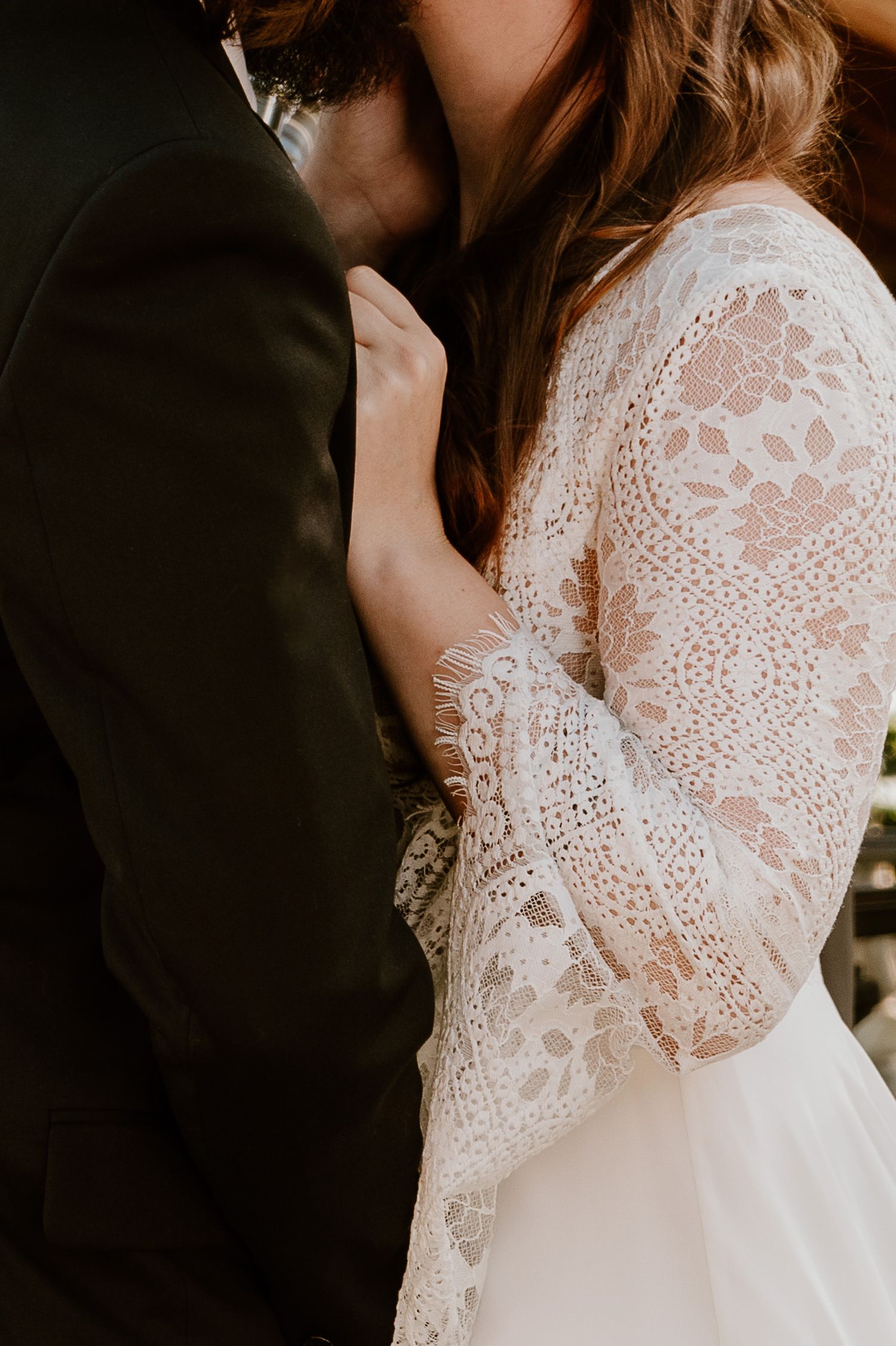 Bride holding groom close during intimate wedding detail portrait