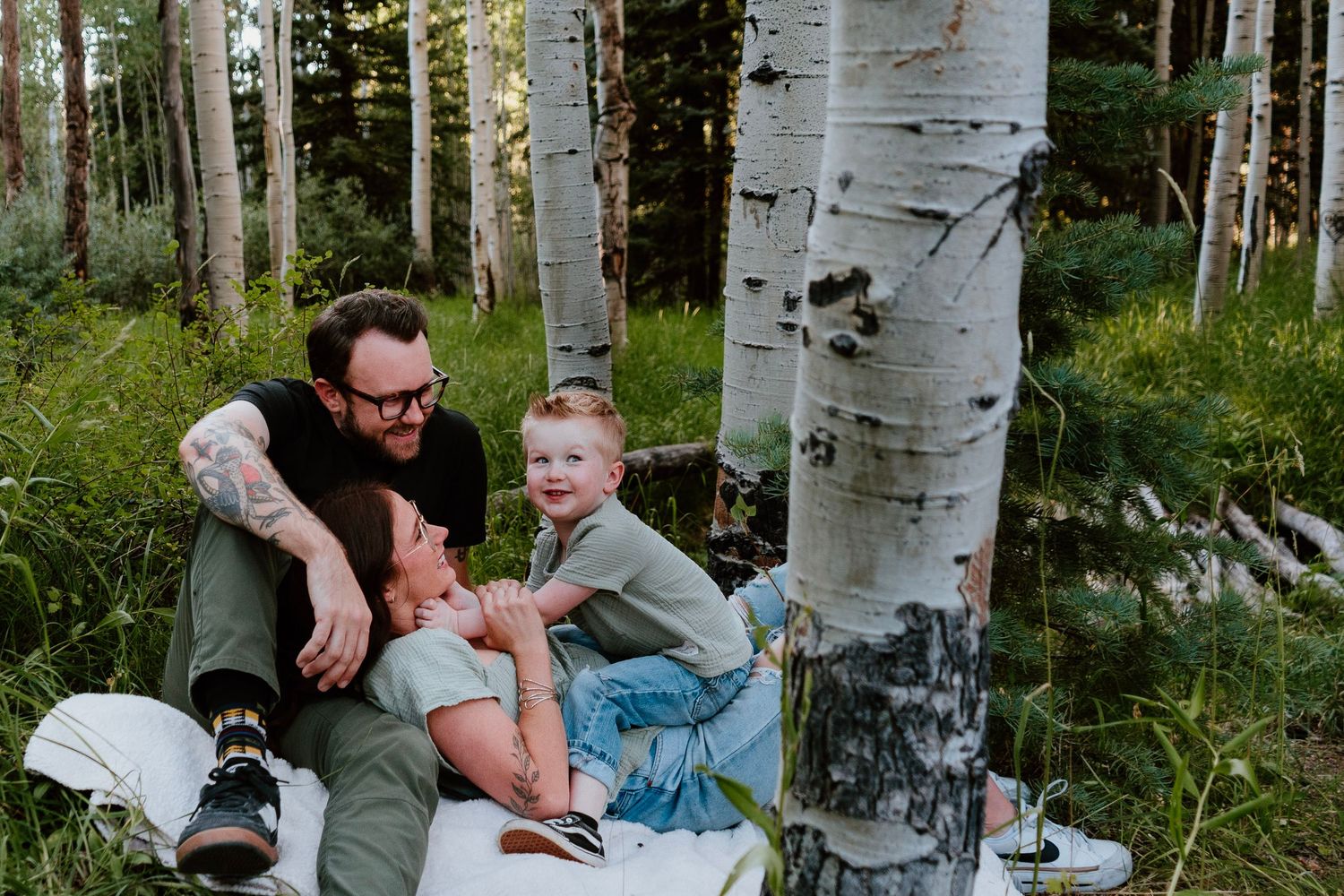 Family session in mountain forest with parents and children sitting together