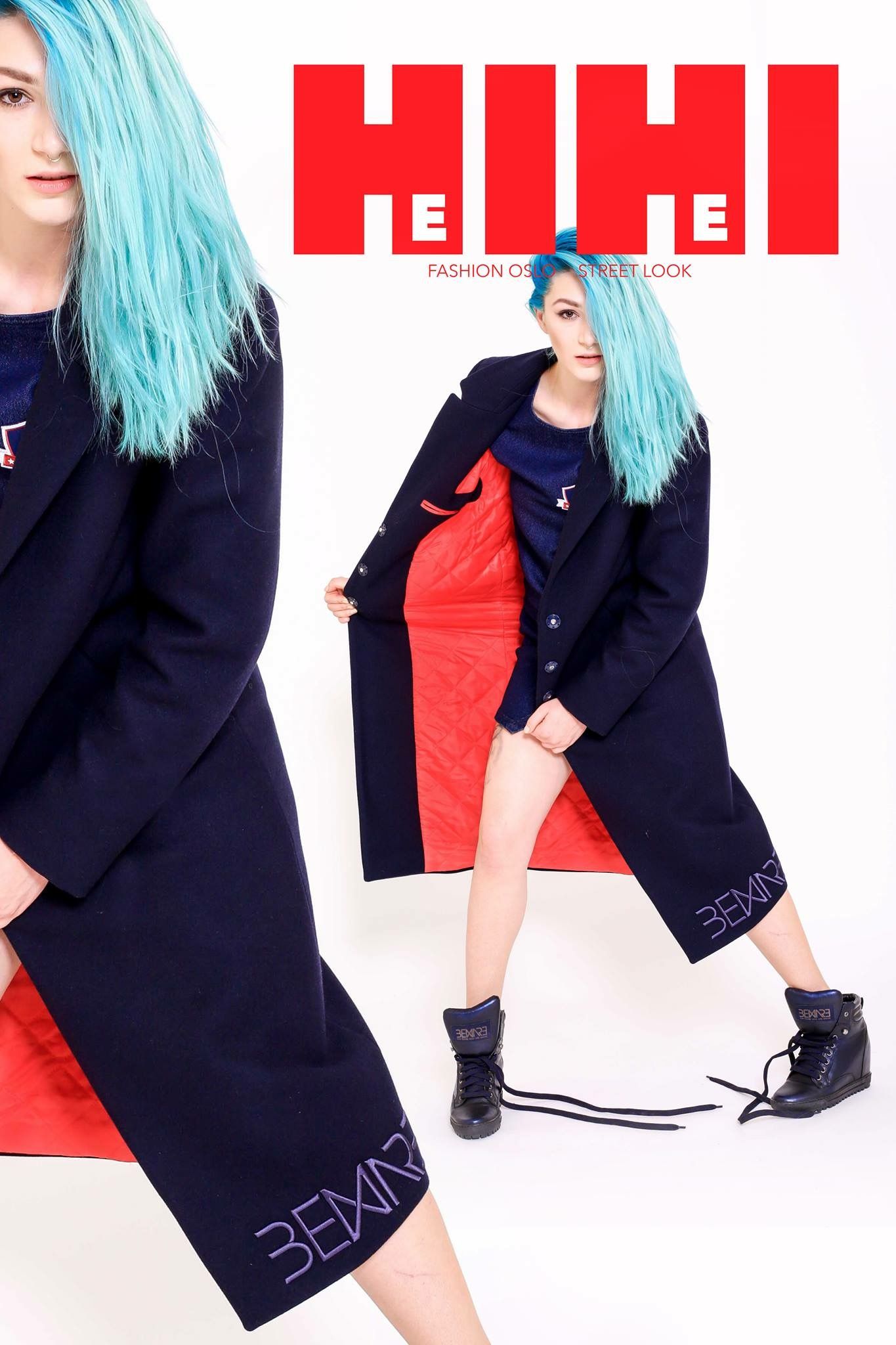 Model with teal blue hair wearing navy longline coat over red dress in fashion editorial.