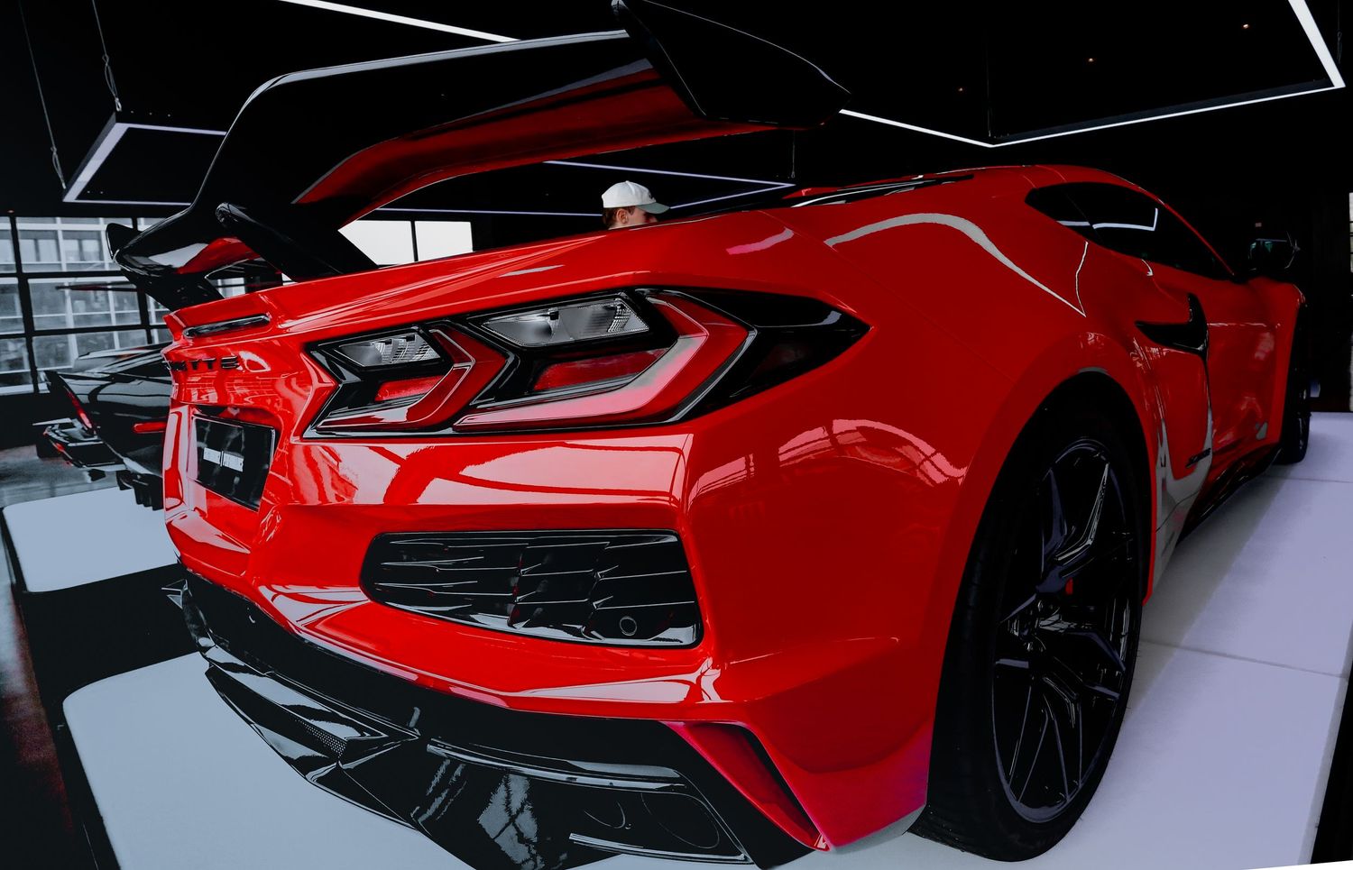 Rear view of a red Chevrolet Corvette C8 with aggressive styling in a showroom.