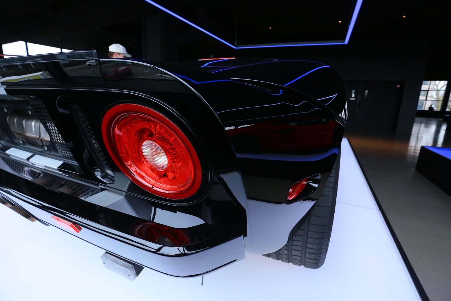 Close-up rear corner of a black classic car with a vivid red taillight.