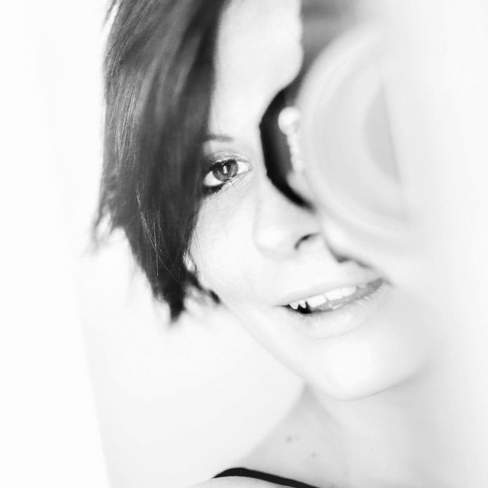 Black and white portrait of smiling woman with soft focus artistic blur effect.