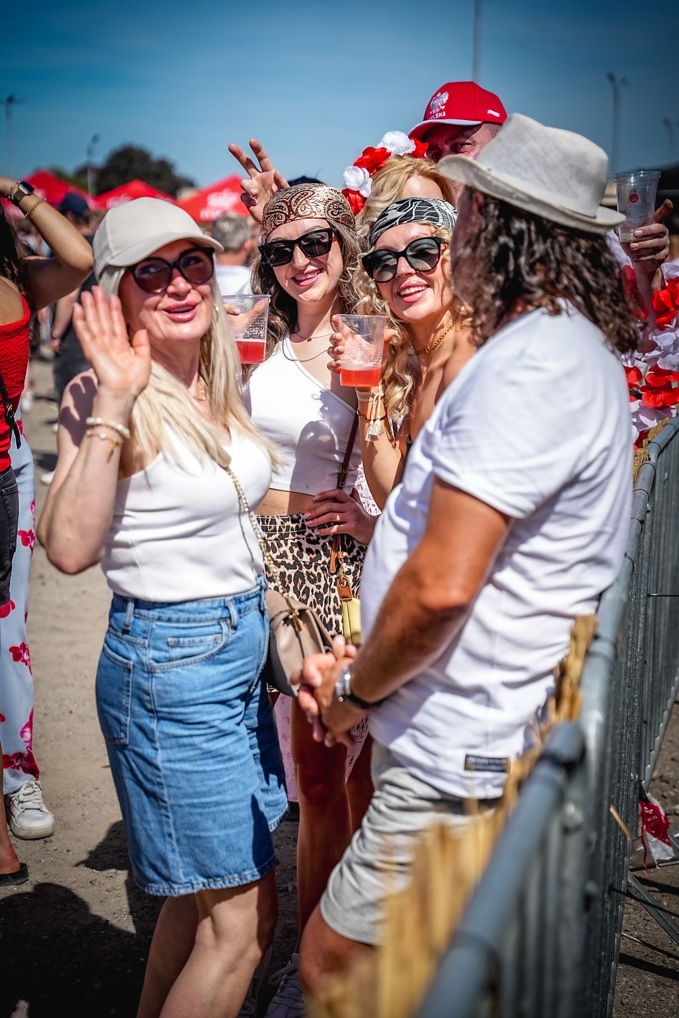 Women in red and white outfits celebrate at Polonia Summer Festival outdoor event on a sunny day.