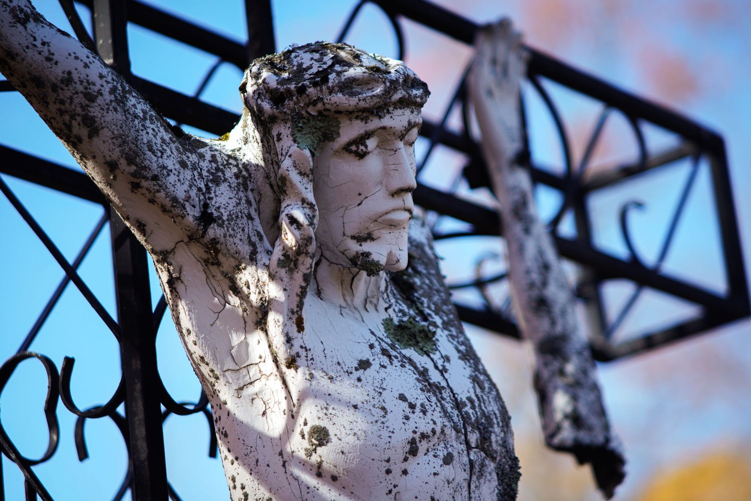 Jesus statue on the cross battered by time.