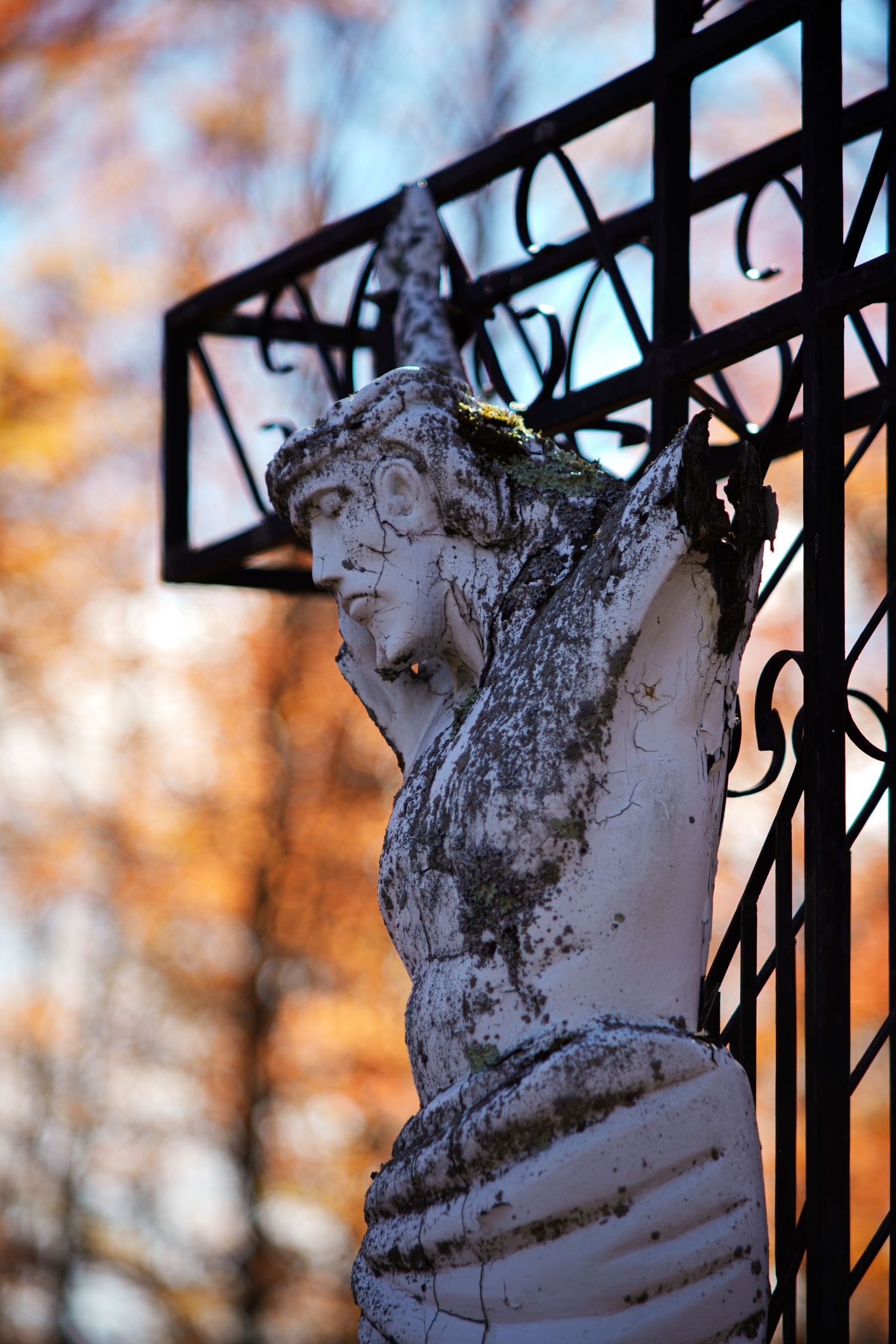 Jesus statue on the cross battered by time.