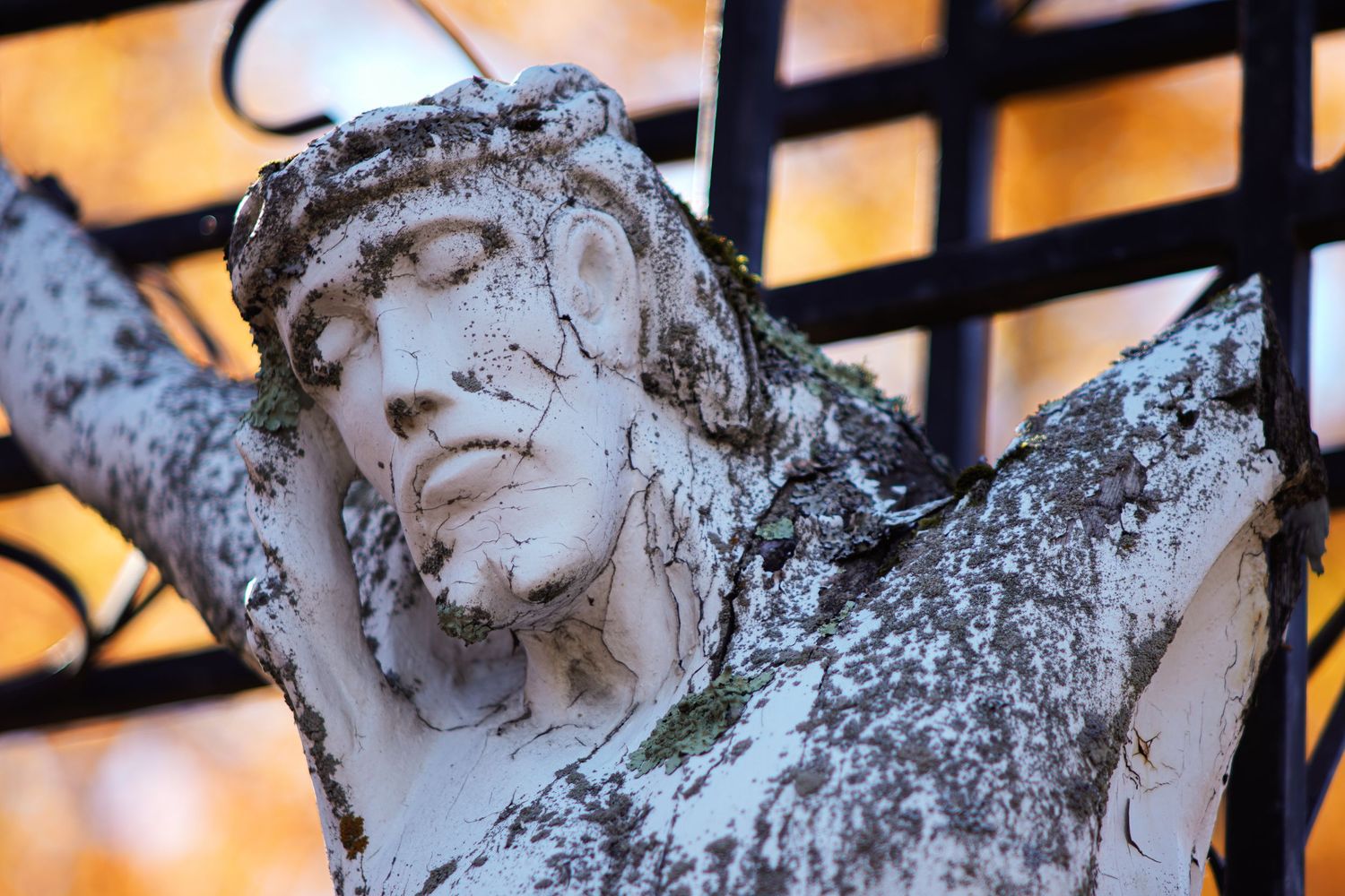 Jesus statue on the cross battered by time.