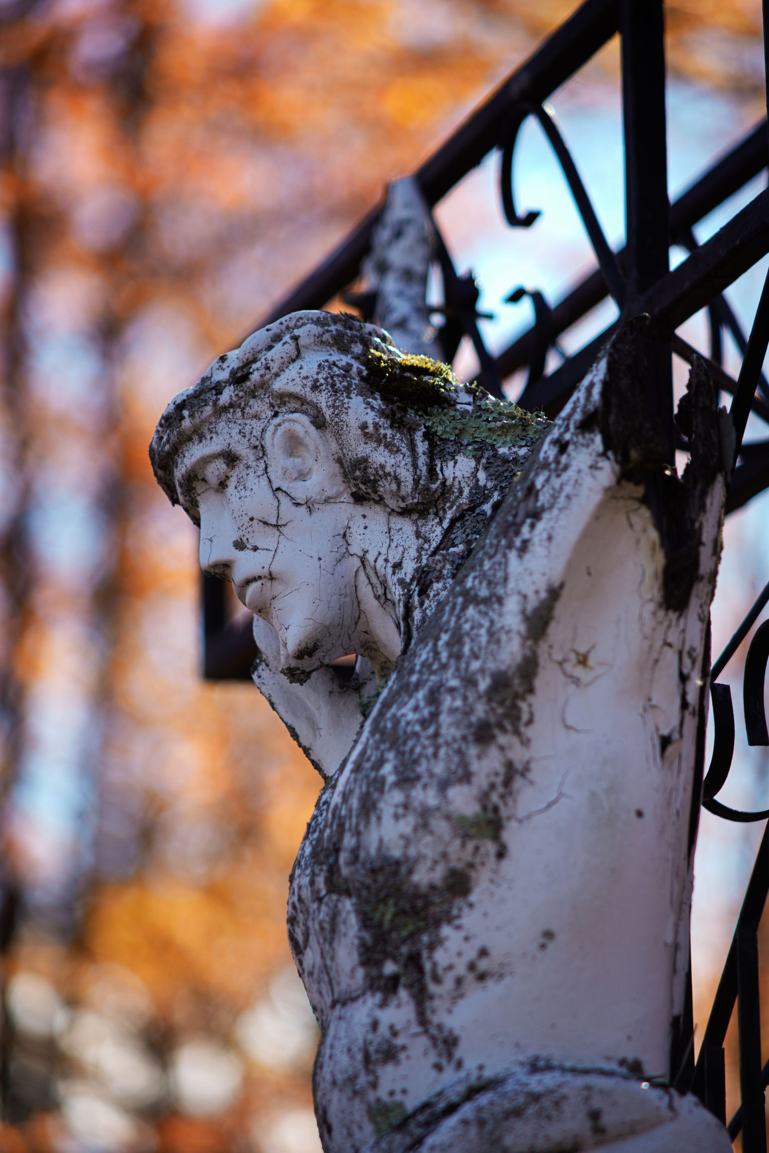 Jesus statue on the cross battered by time.