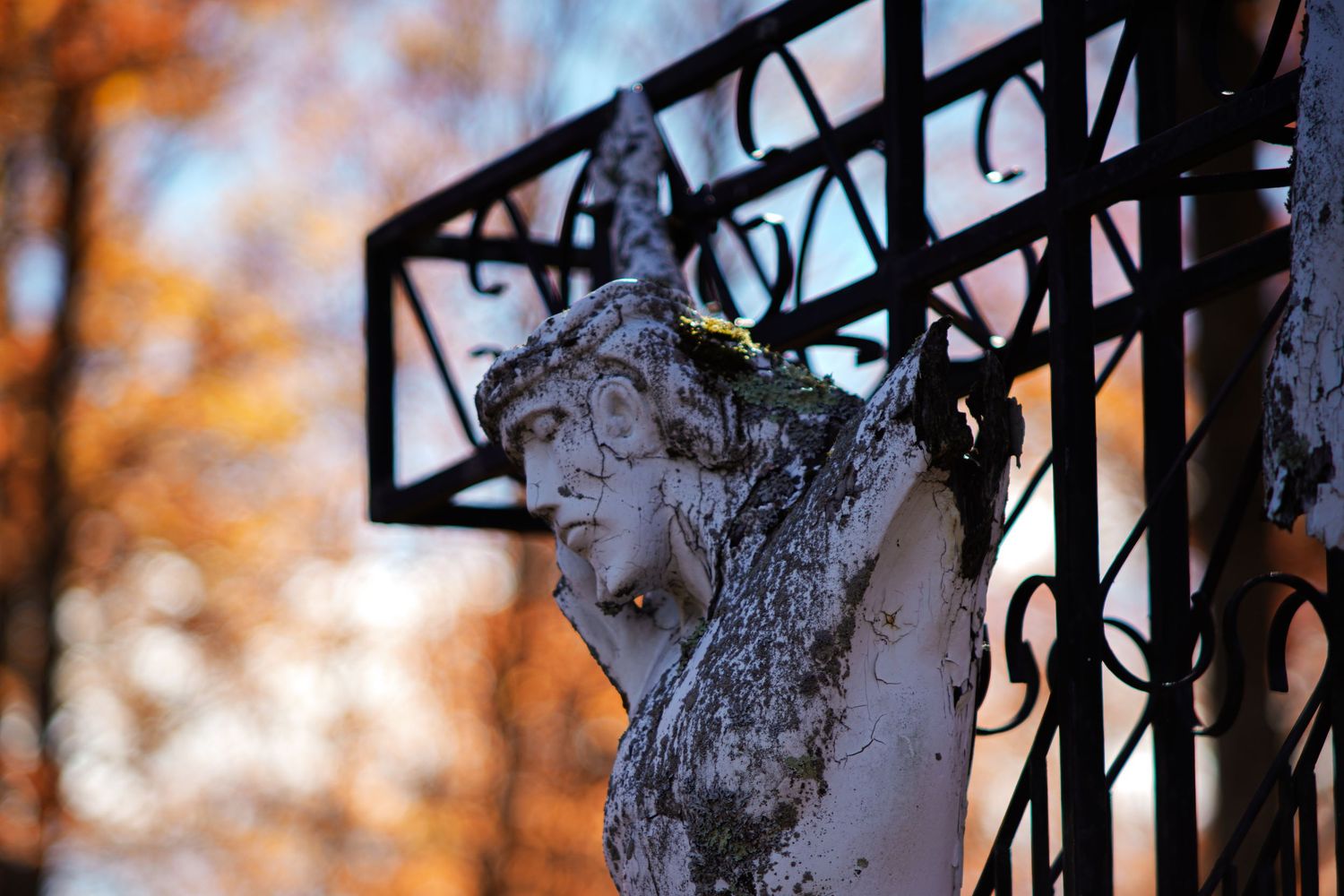 Jesus statue on the cross battered by time.