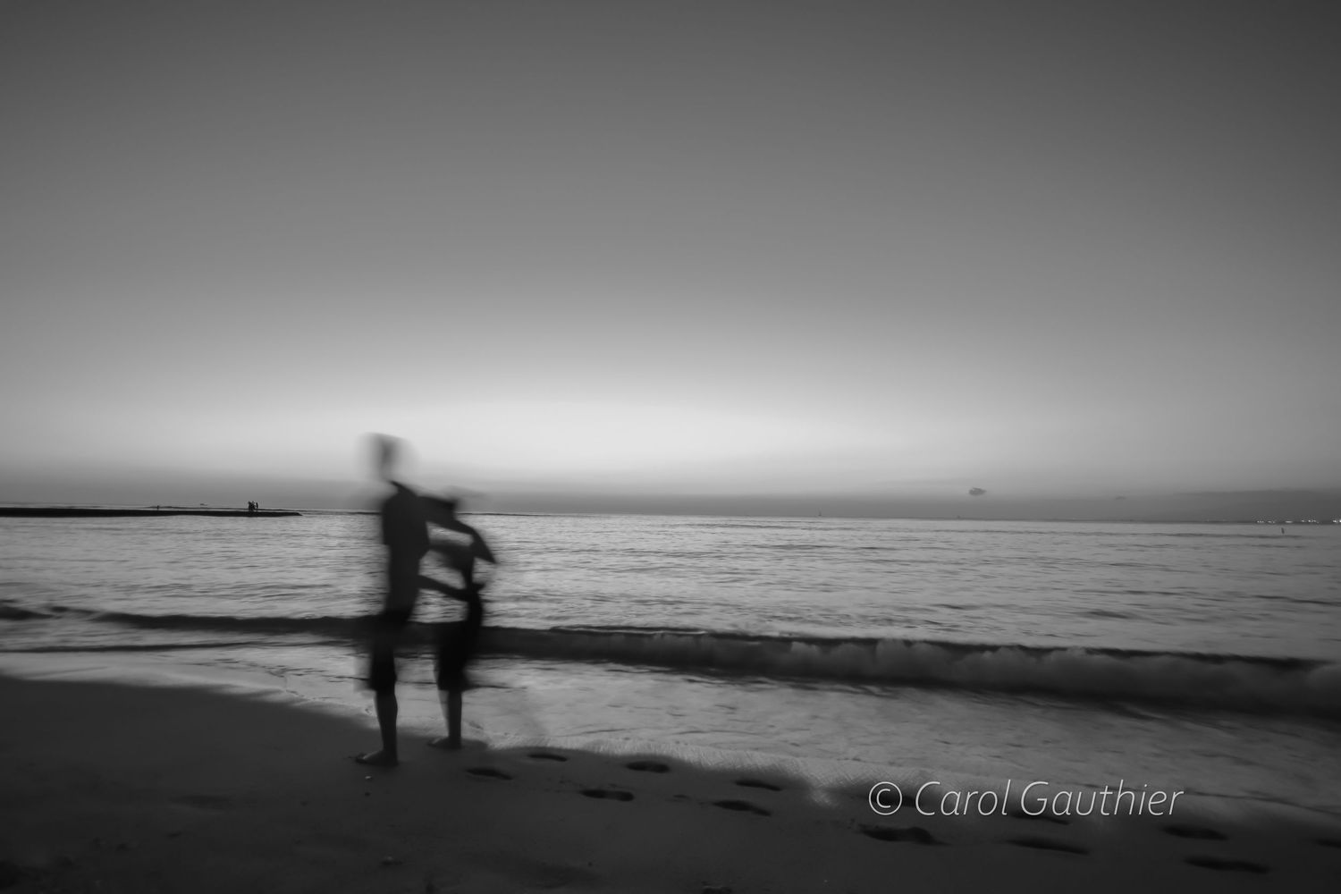Running shadows on the beach at sunset in Hawaii. Black and white.