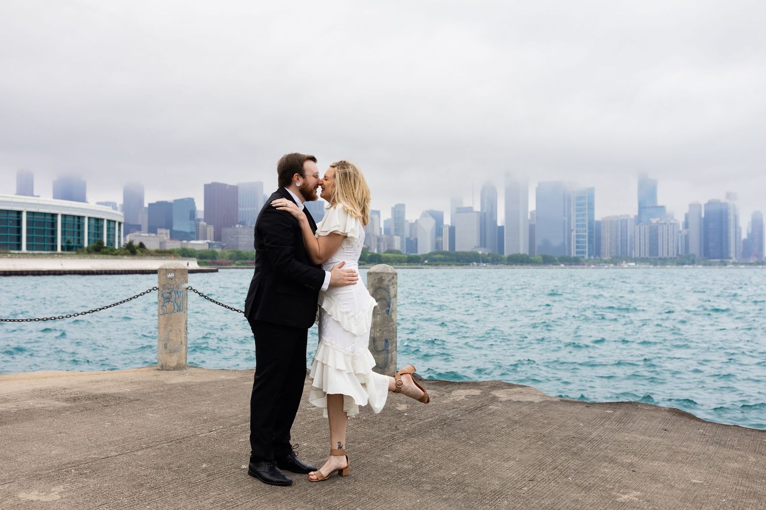 Couple shares a kiss on the waterfront with the stunning Chicago skyline in the background.