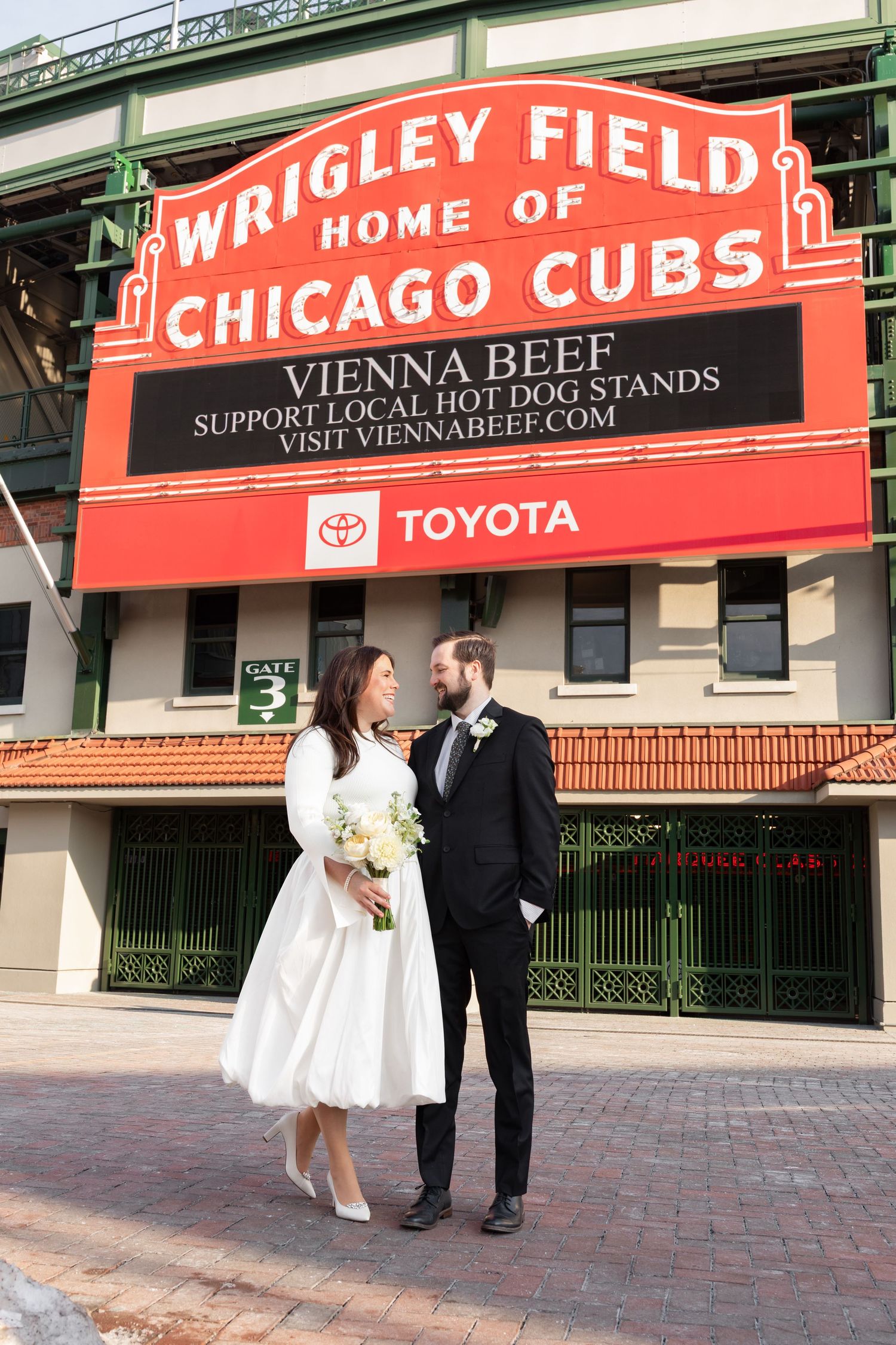 Bride and groom sharing a romantic look outside Wrigley Field Home of the Chicago Cubs on their wedding day.