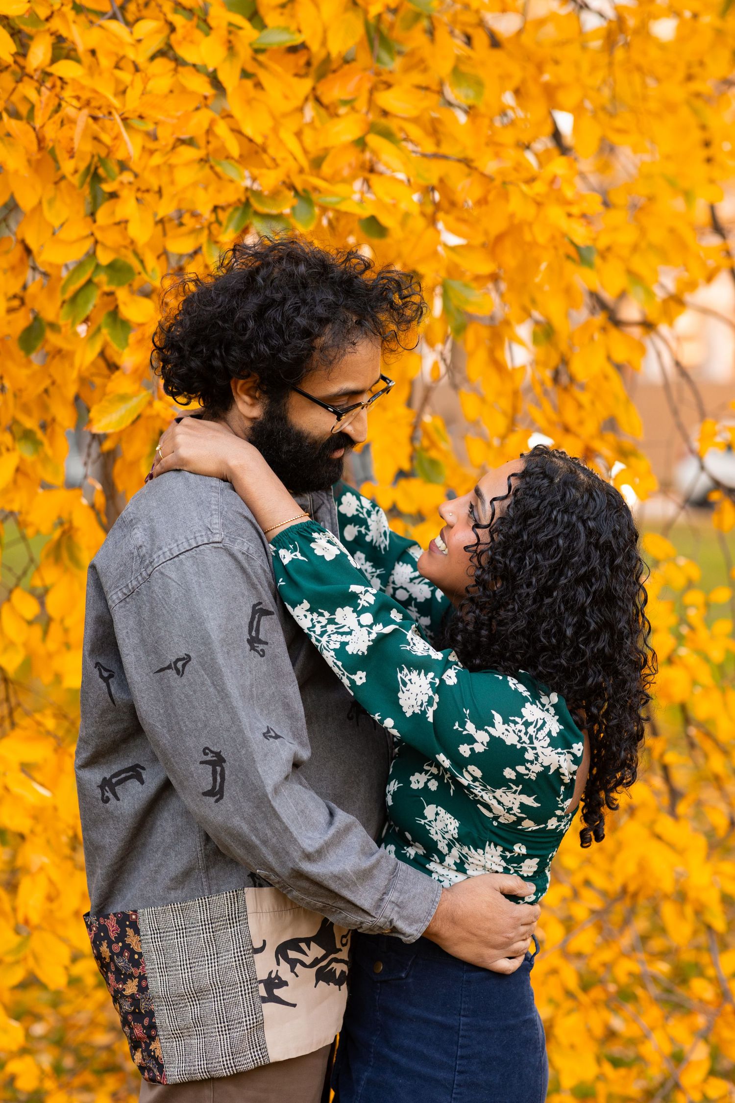 Romantic couple embracing against a stunning backdrop of golden autumn foliage.