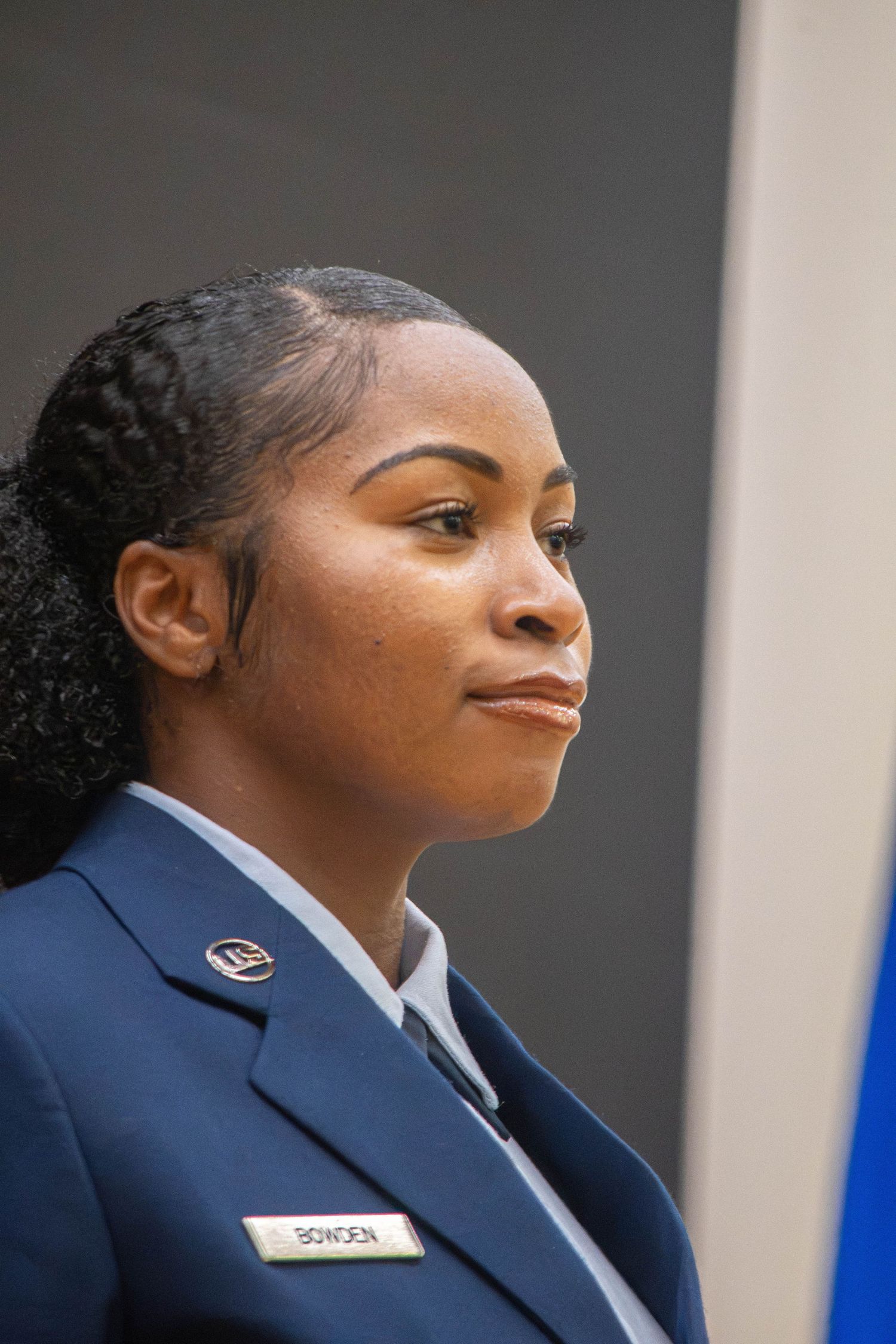Female US Air Force airman named Bowden in dress blue uniform looking to the side.