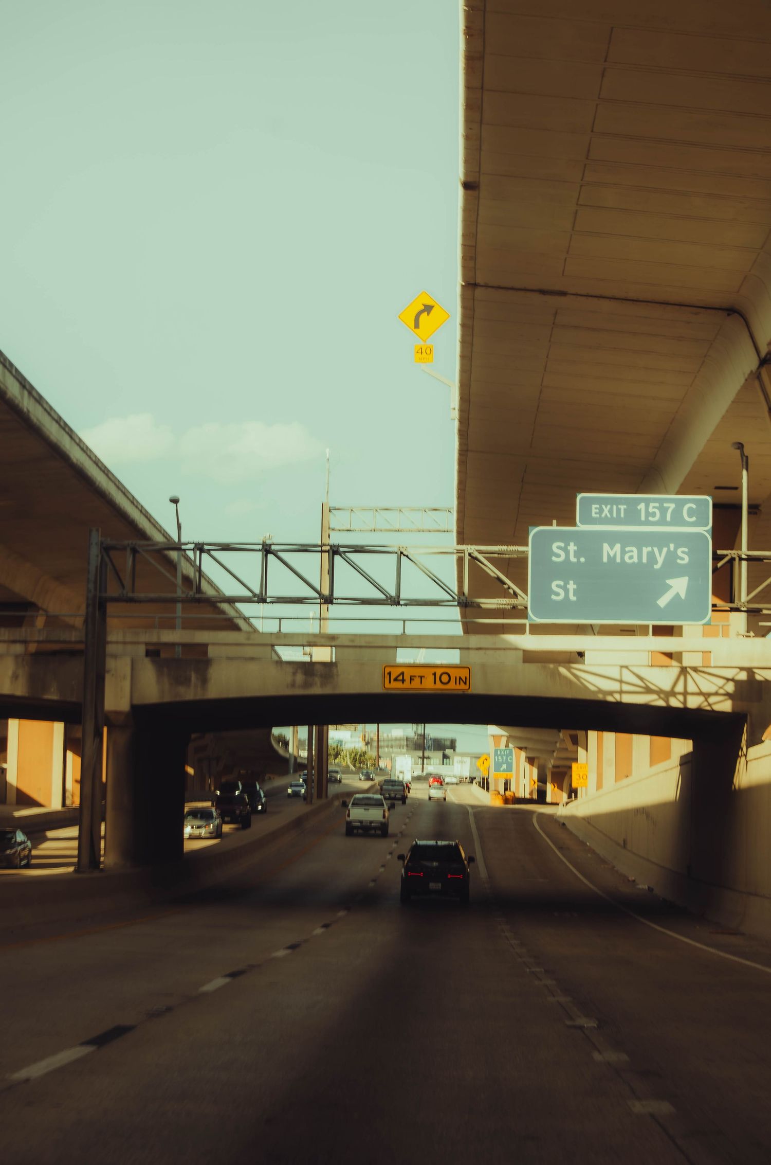 Highway underpass with Exit 157C St. Mary's Street sign and cars passing beneath bridges.