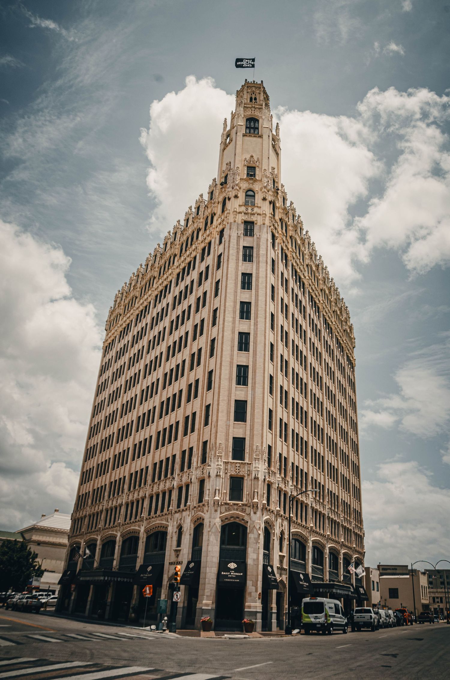 Tall Art Deco skyscraper with ornate Gothic details towering against a dramatic cloudy sky.