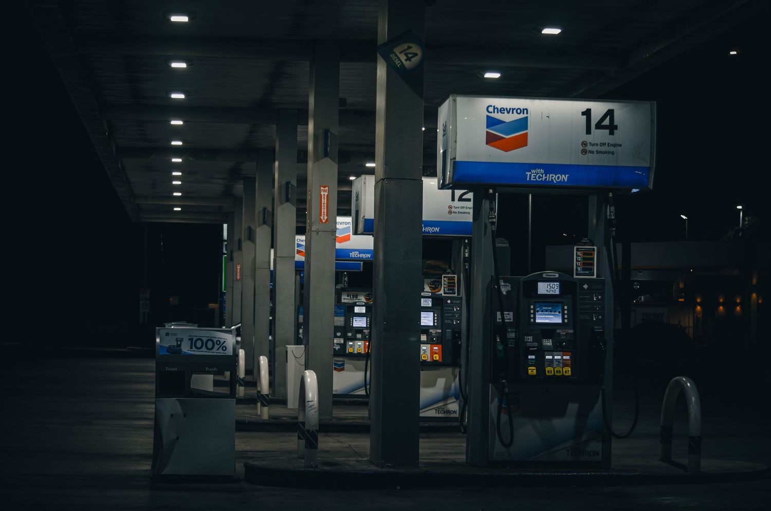 Chevron gas station pump number 14 illuminated at night with blue and white signage.