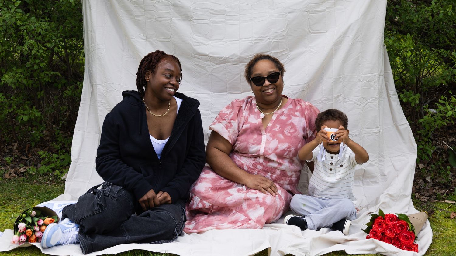 Family sitting together outdoors during a portrait session