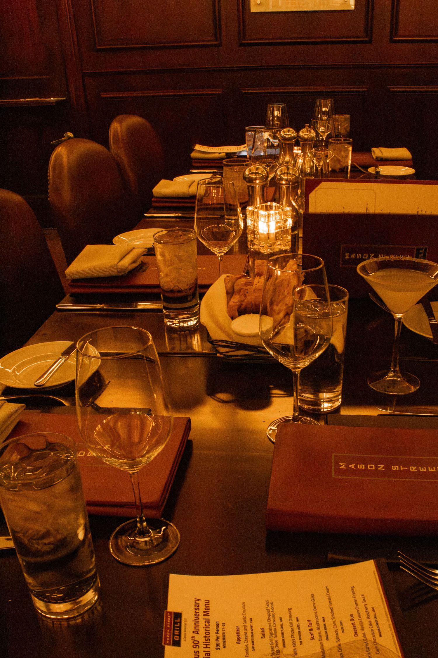 Dimly lit restaurant table with candles and dinner place settings
