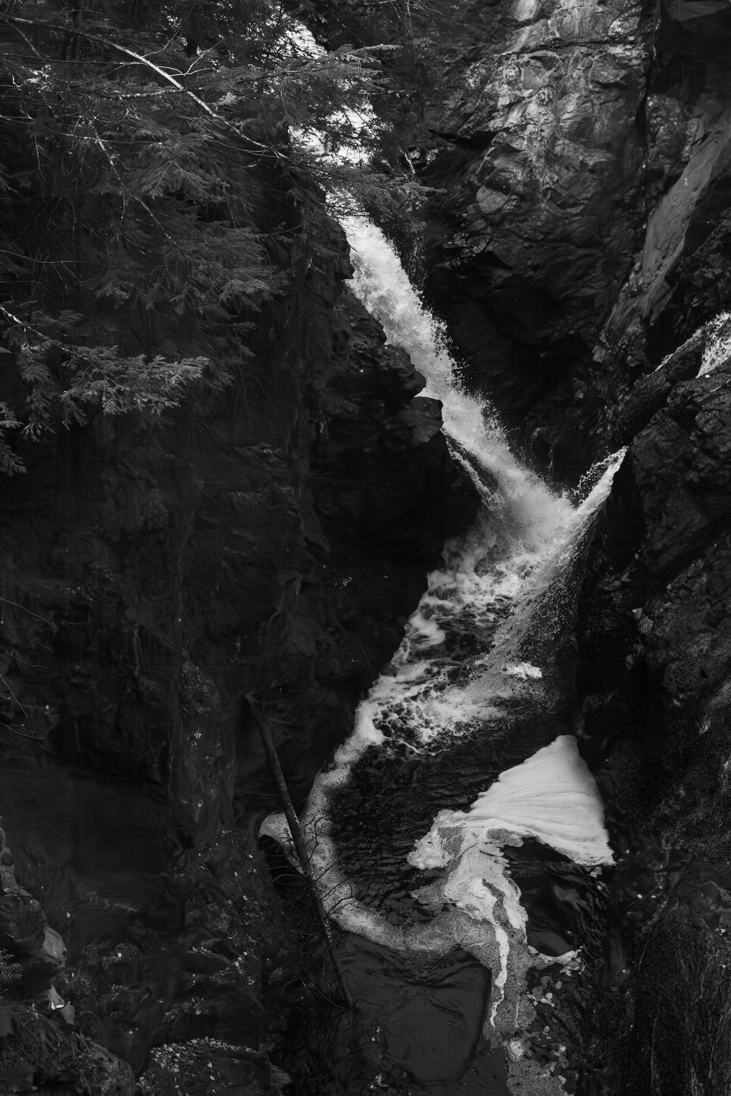 Close-up of flowing water between dark rocks