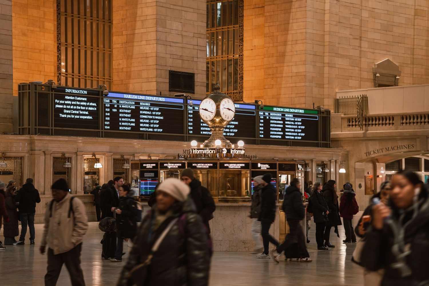 Crowds of commuters walk beneath the iconic departure boards at Grand Central Terminal New York.