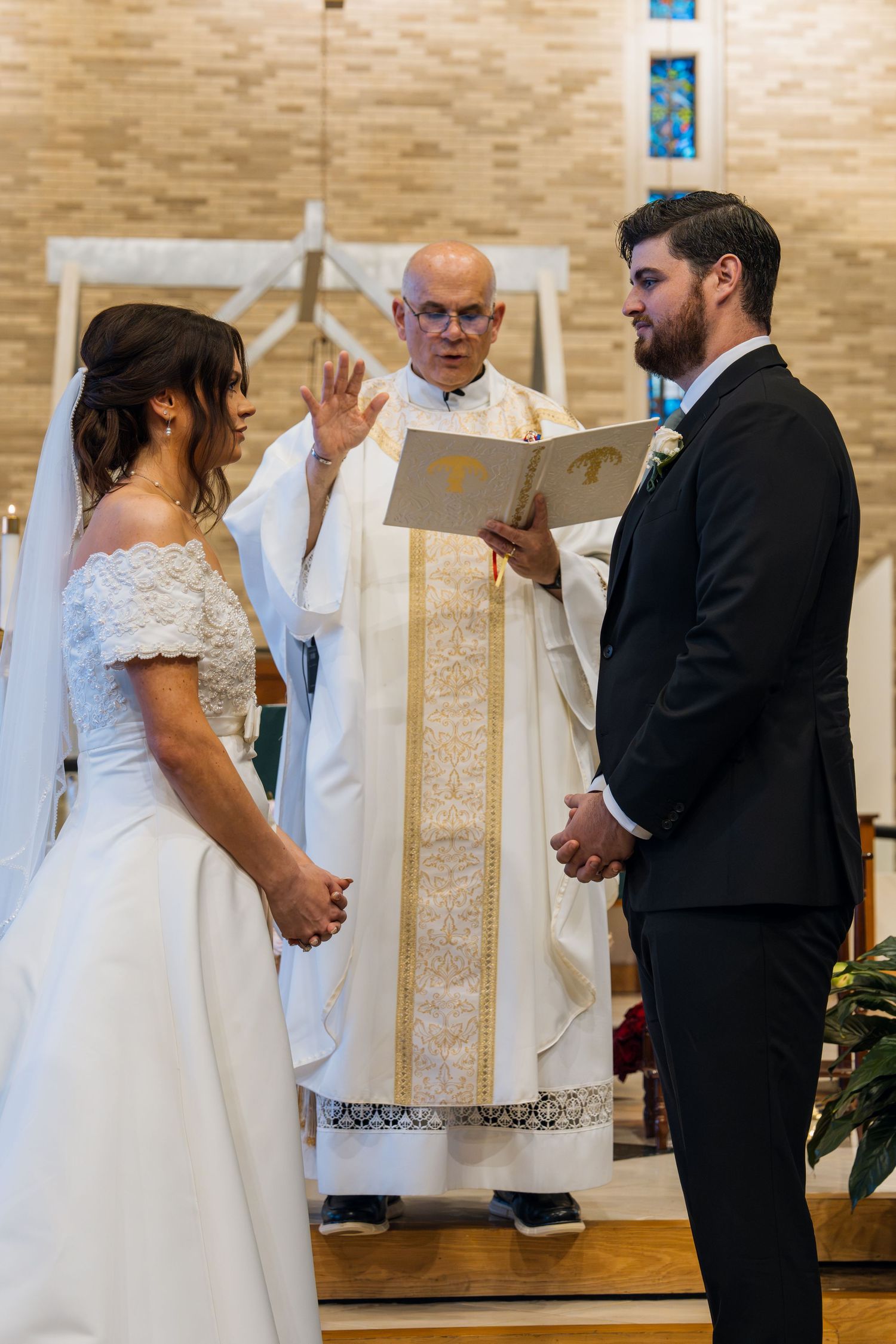 Bride and groom exchange vows before a priest during a traditional church wedding ceremony.