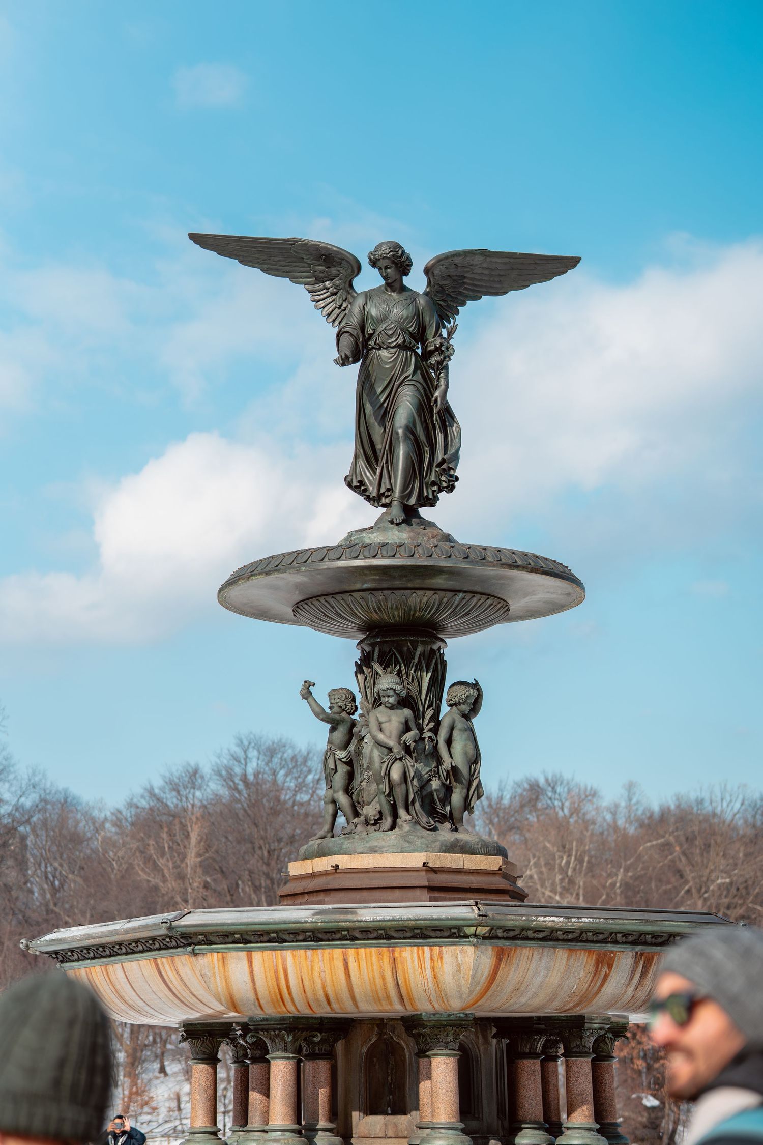 Angel of the Waters bronze statue atop Bethesda Fountain with blue sky in Central Park, NYC.