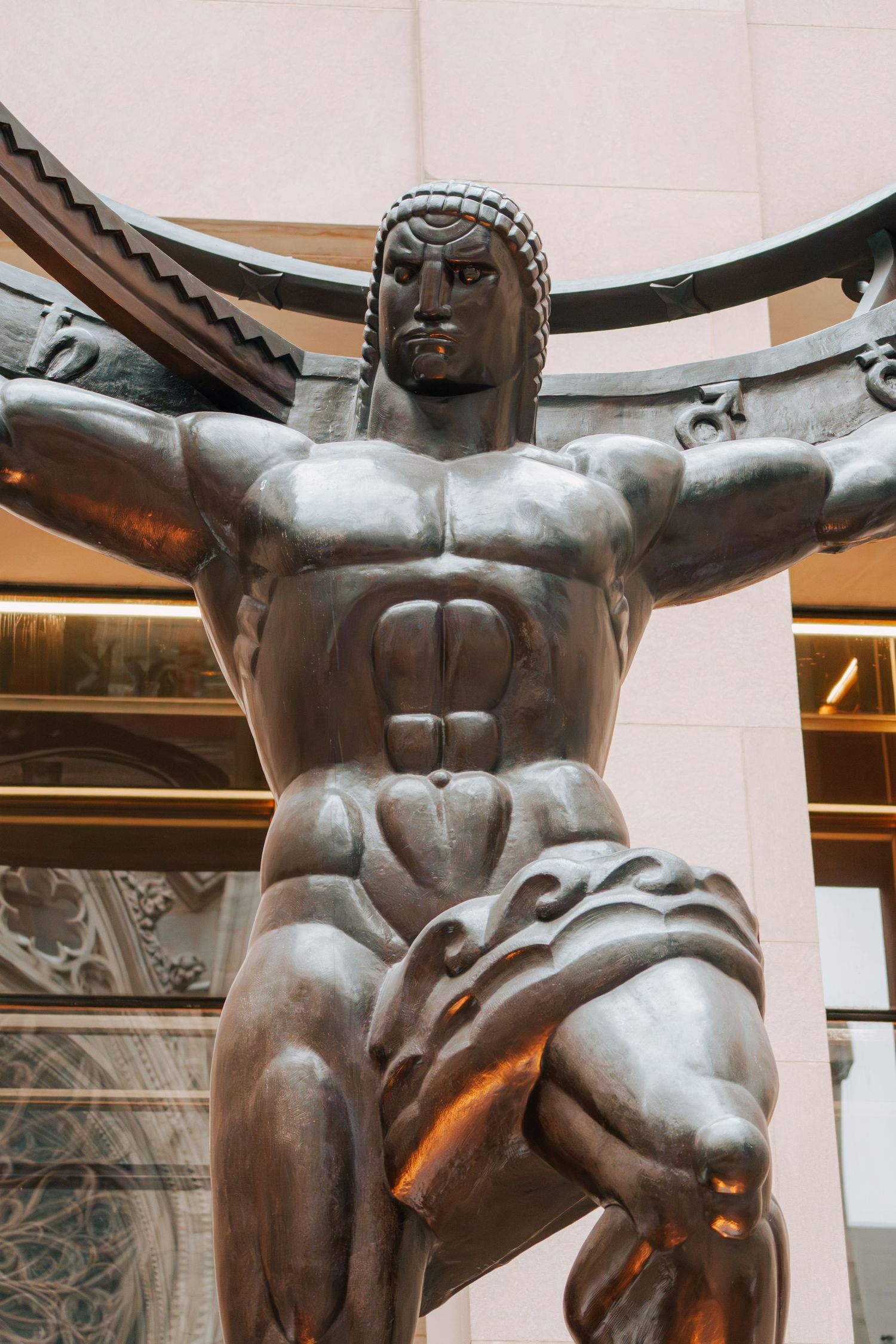Bronze muscular Atlas statue holding celestial sphere at Rockefeller Center, New York City.
