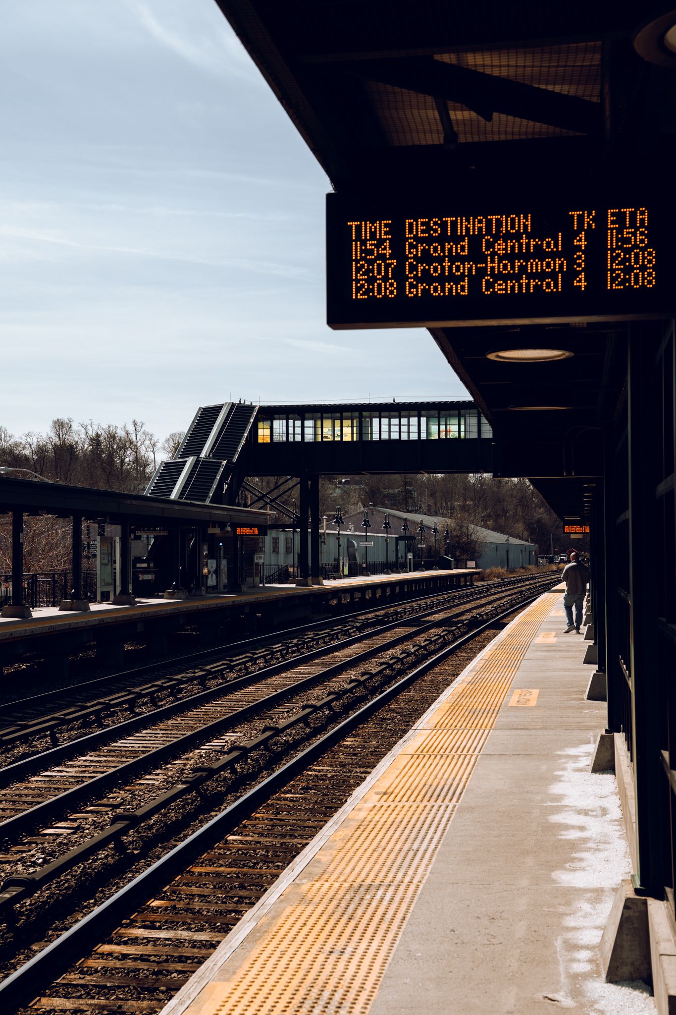 Metro-North train station digital departure board showing Grand Central and Croton-Harmon destinations with ETAs.