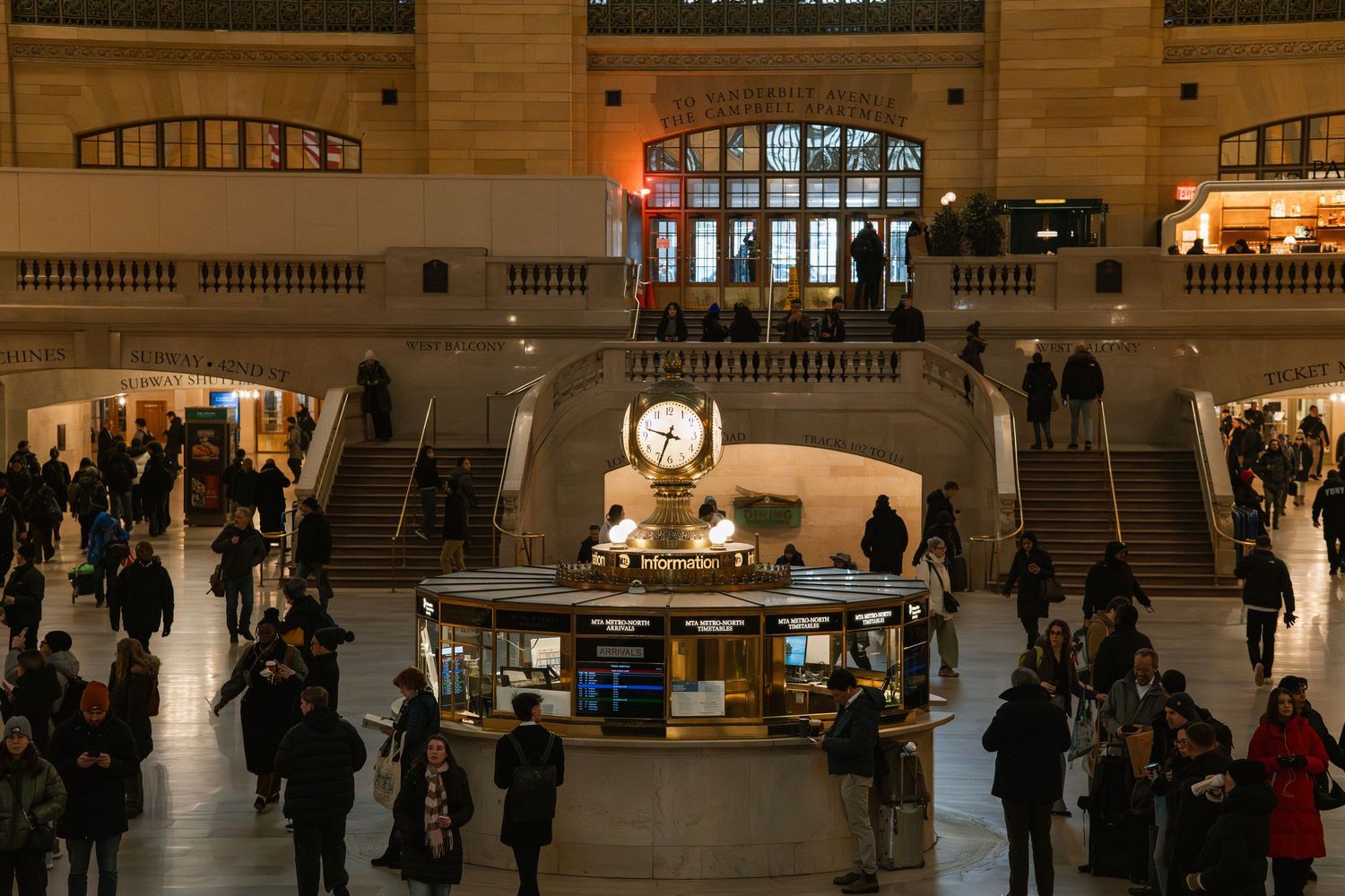 Aerial view of Grand Central Terminal main concourse with travelers surrounding the iconic central clock booth.
