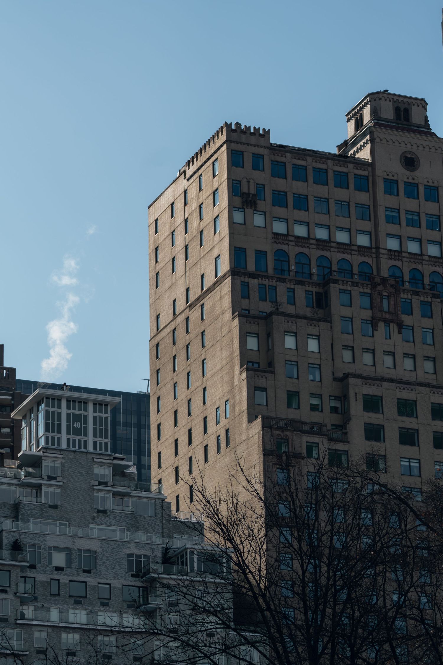 Classic brick high-rise buildings with ornate architecture under a clear blue sky.