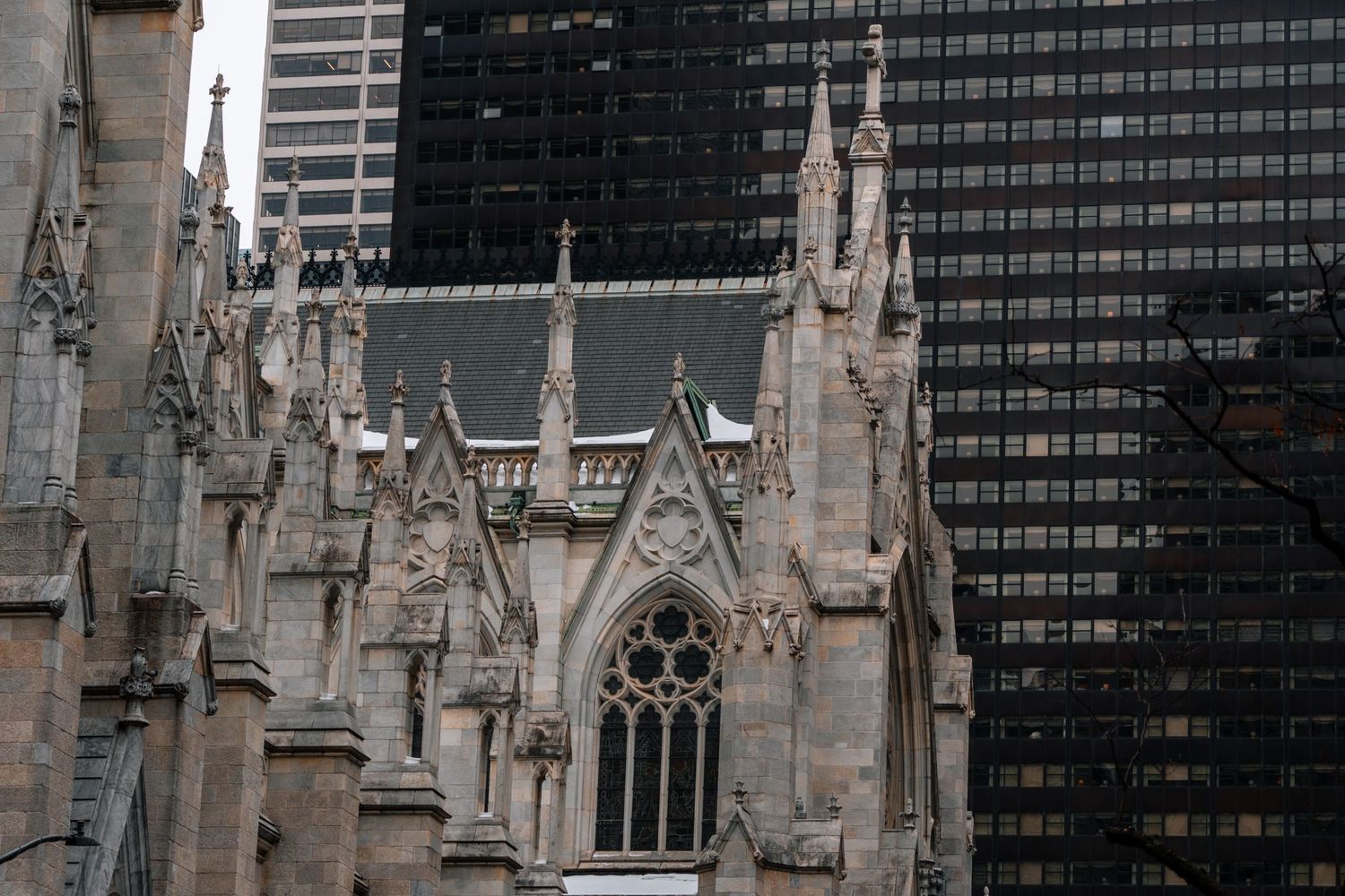 Gothic architecture of St. Patrick's Cathedral with ornate stone details and modern skyscrapers behind.
