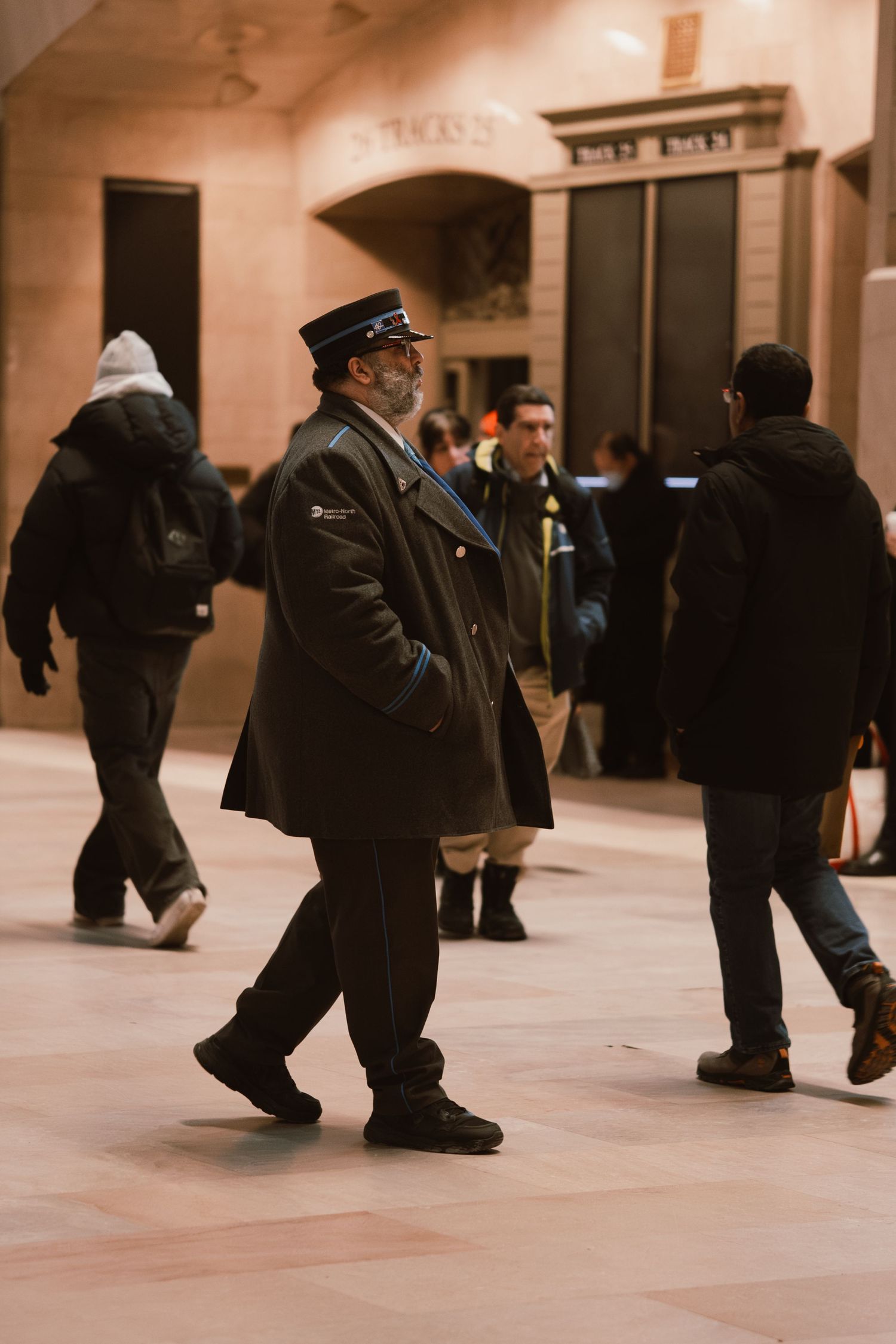 A uniformed officer walks through the busy concourse of Grand Central Terminal in New York City.