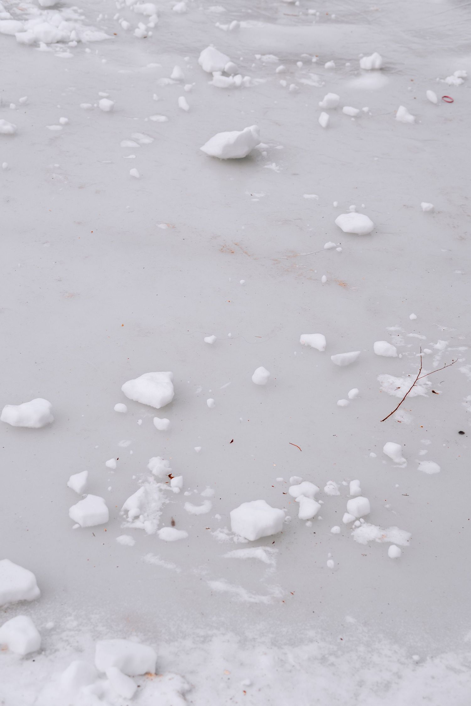 Chunks of ice and snow scattered across a frozen surface during winter.
