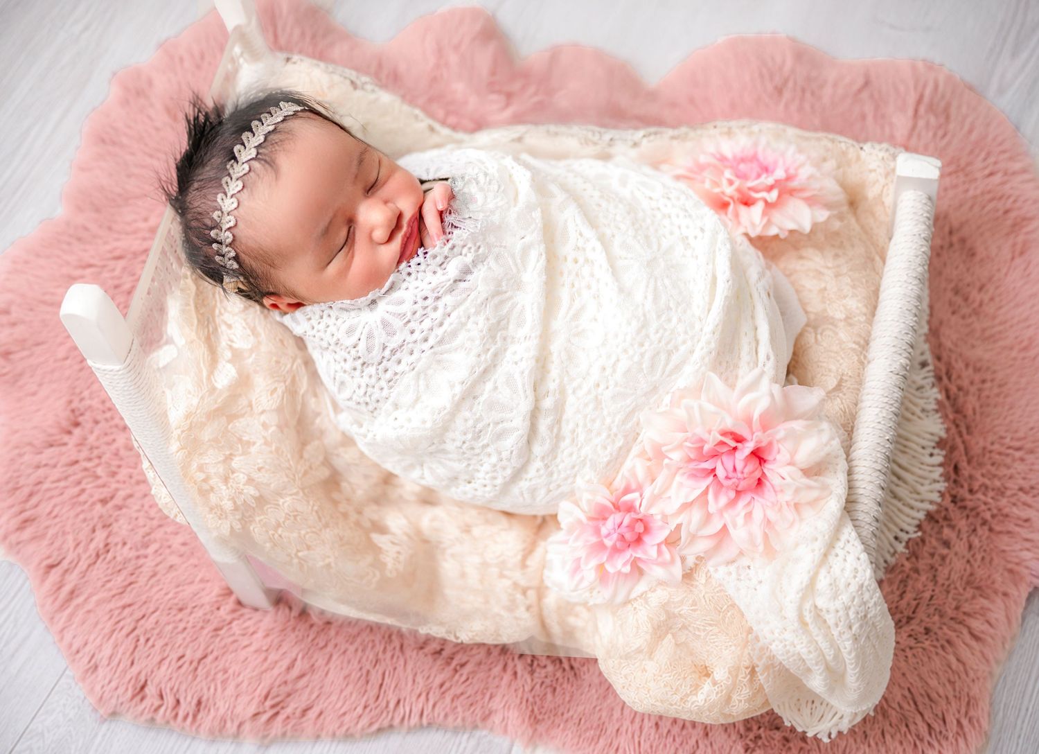 In studio Hillcrest North Shore, newborn baby wrapped in floral pink blanket – Auckland newborn photographer