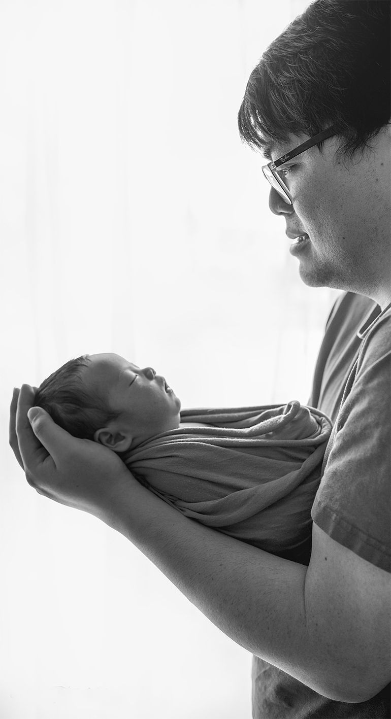 In studio Hillcrest North Shore, Black and white portrait of parent holding newborn baby – Auckland newborn photographer