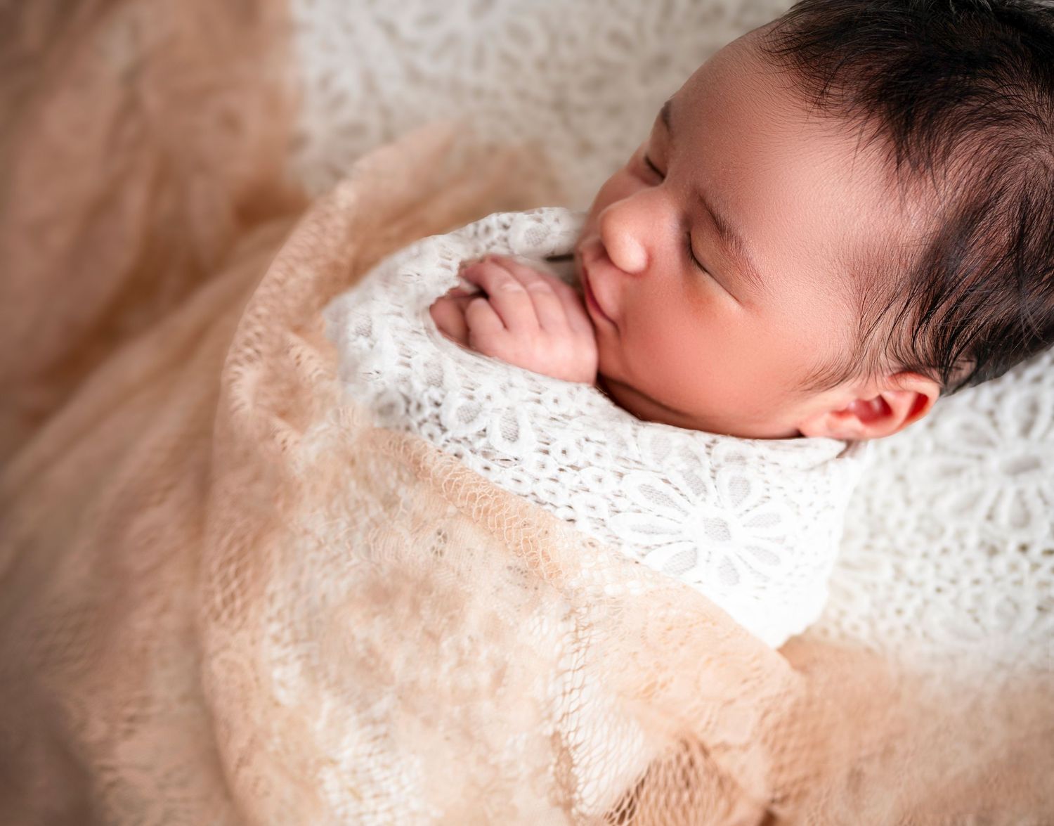 Sleeping newborn baby wrapped in soft neutral tones – studio newborn photography Hillcrest, Auckland North Shor
