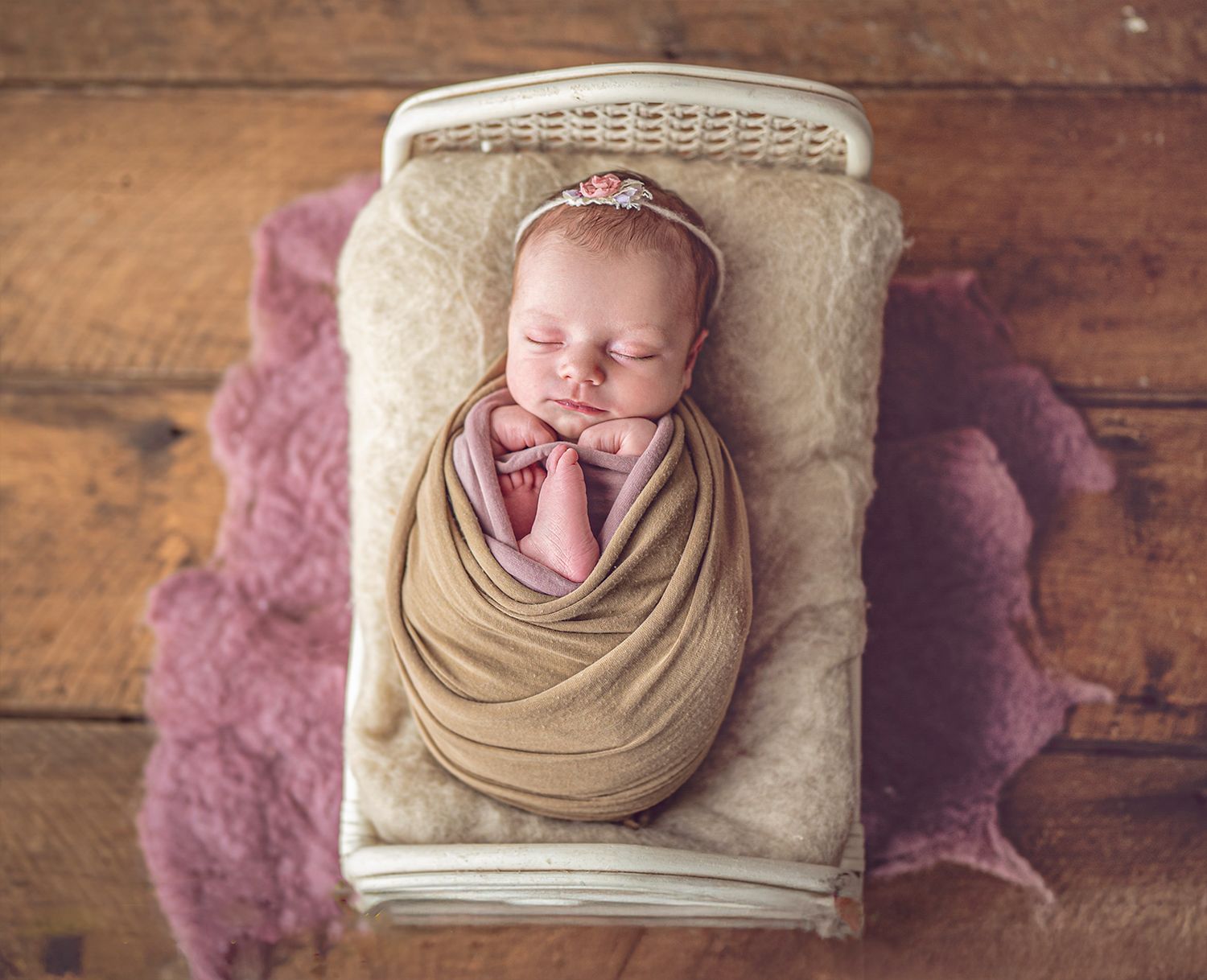 In studio Hillcrest North Shore, Sleeping newborn baby wrapped in neutral tones in a small bed – natural newborn photography Auckland North