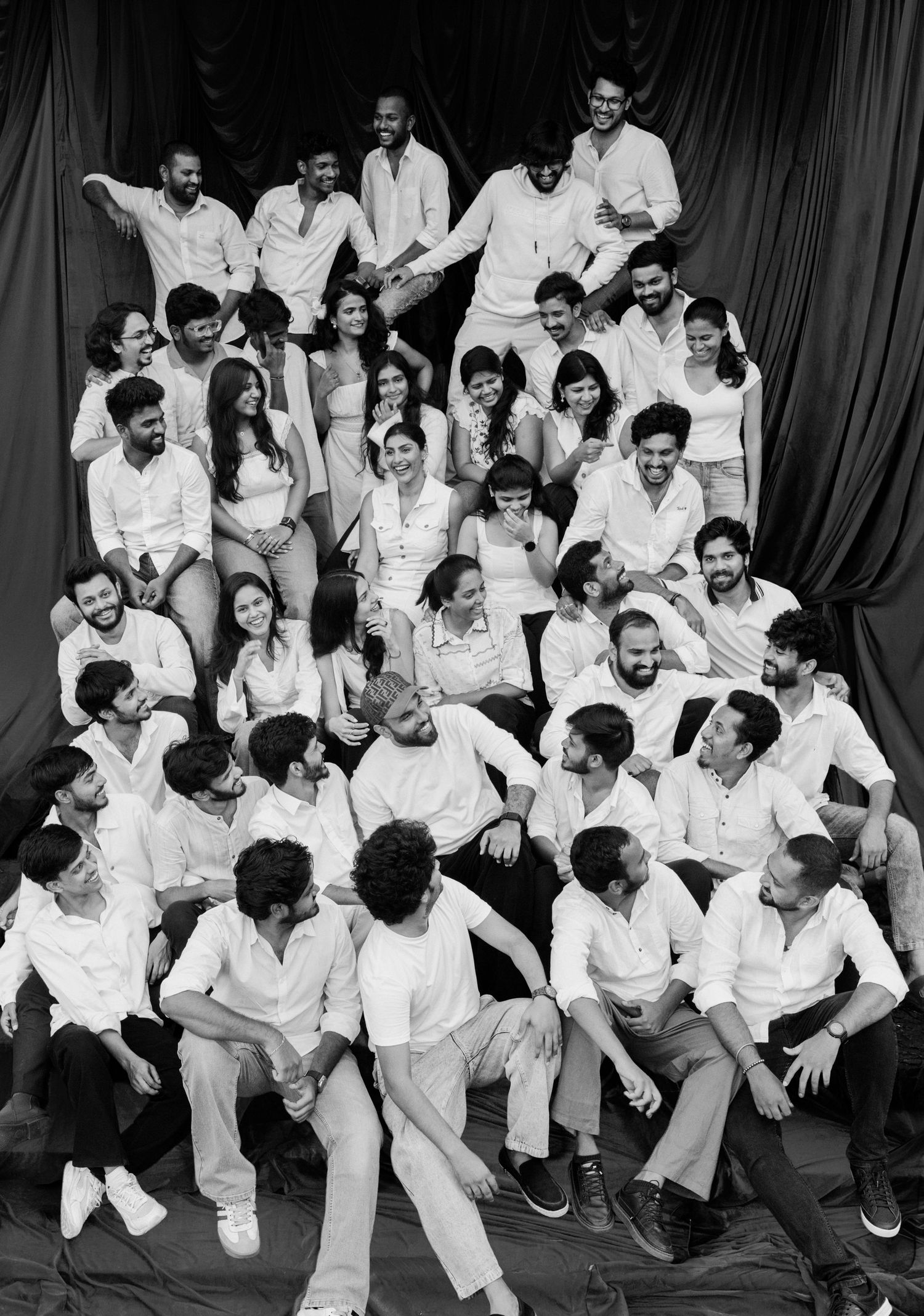 Large group of people dressed in white posing together in a black and white photo.