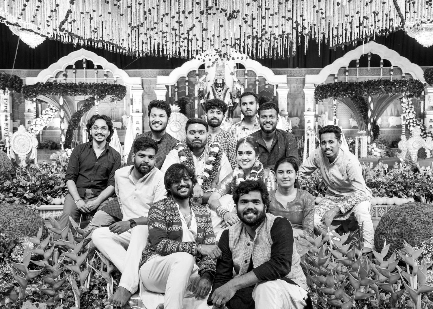 Black and white group photo of young adults posing together at a decorated outdoor celebration venue.