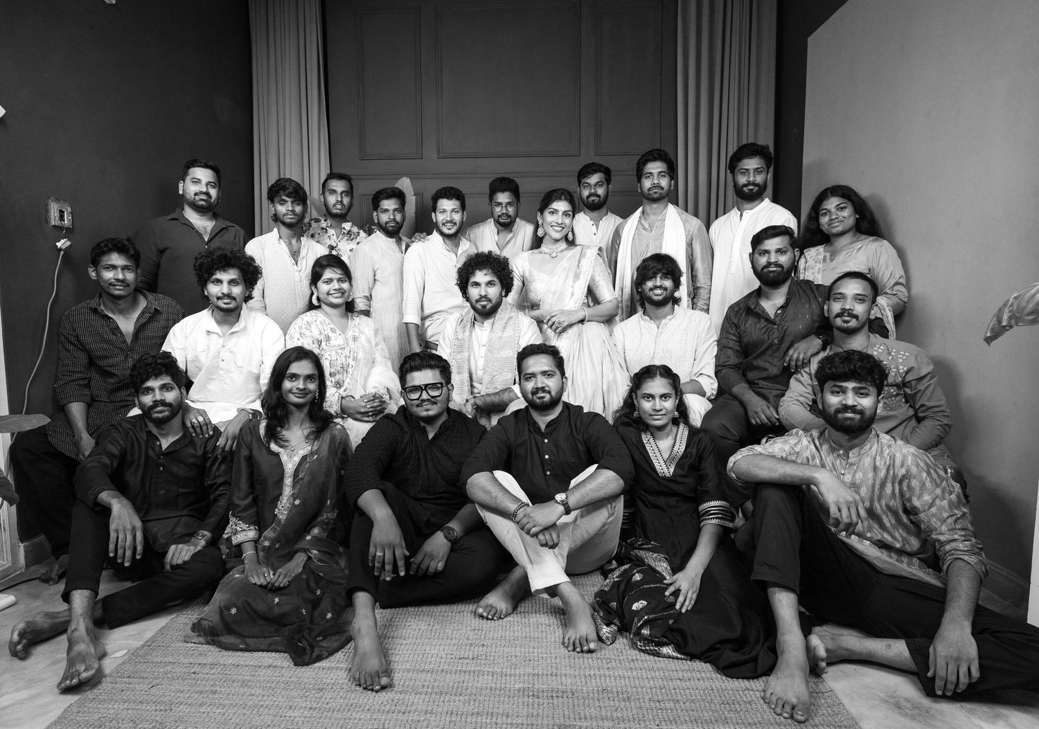 Large group of South Indian film cast and crew posing together for a black and white team photo indoors.