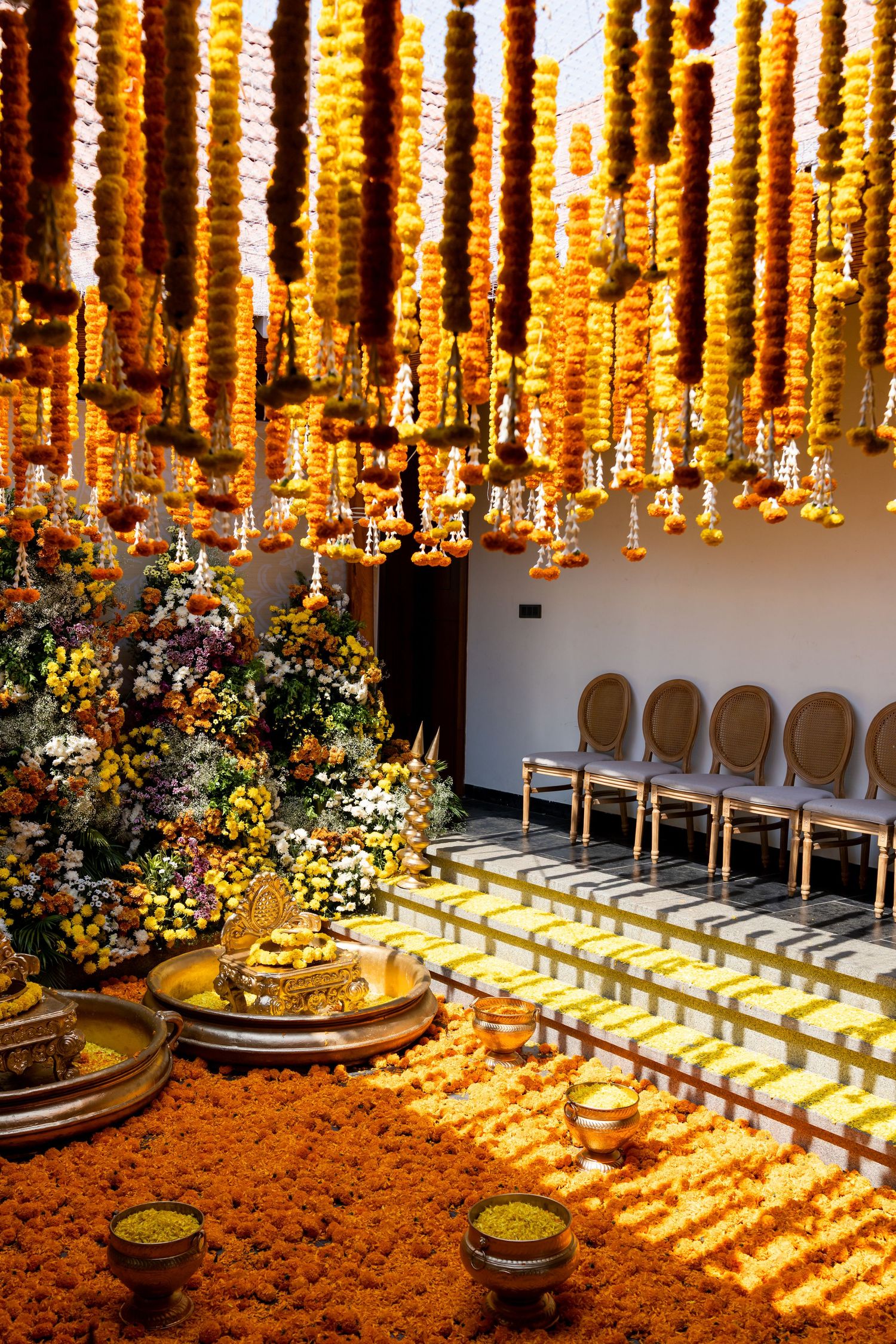 Vibrant Indian wedding mandap adorned with marigold garlands, floral arrangements, and golden ceremonial decor.