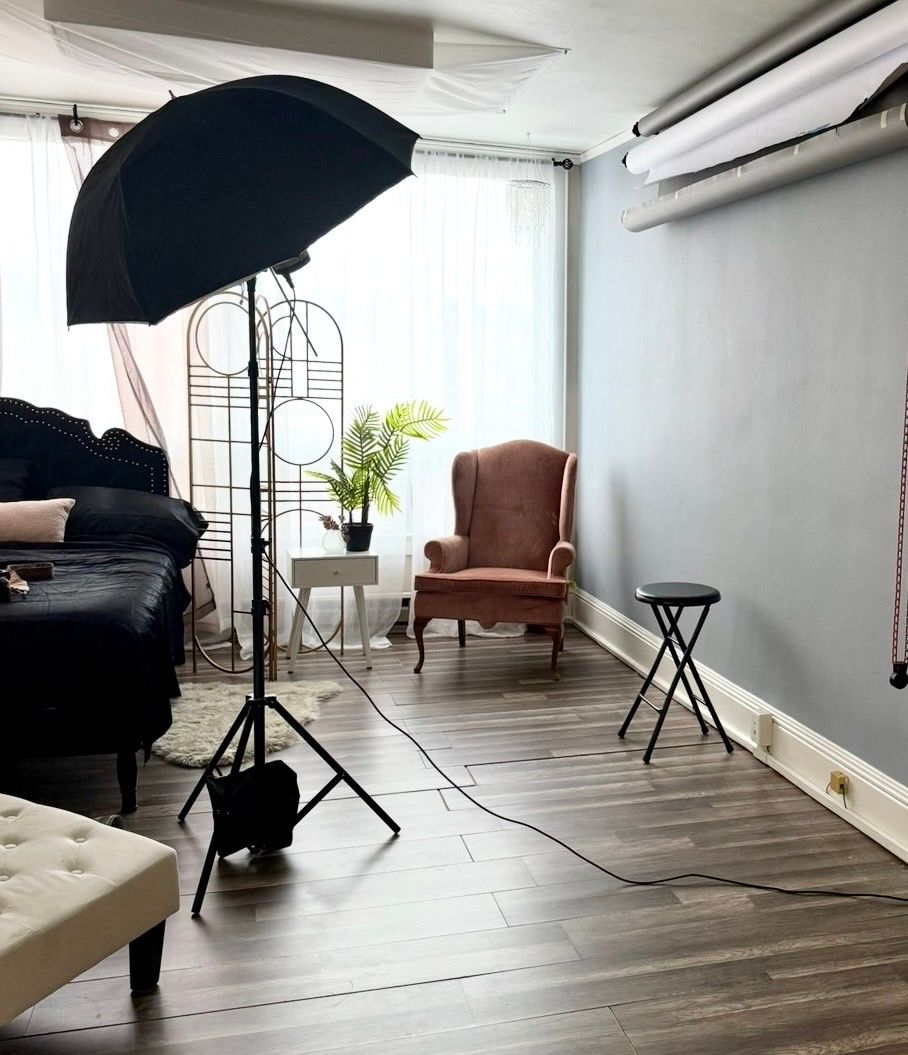 Boudoir Photography studio with umbrella light, decor, and hardwood floors in a bright, minimalist space in Colorado Springs.
