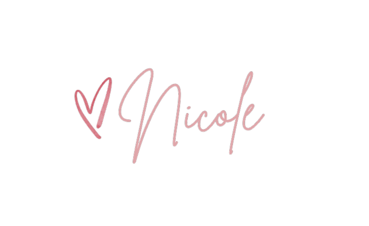 Pink handwritten signature of Nicole with a decorative heart, elegant cursive script on white background.