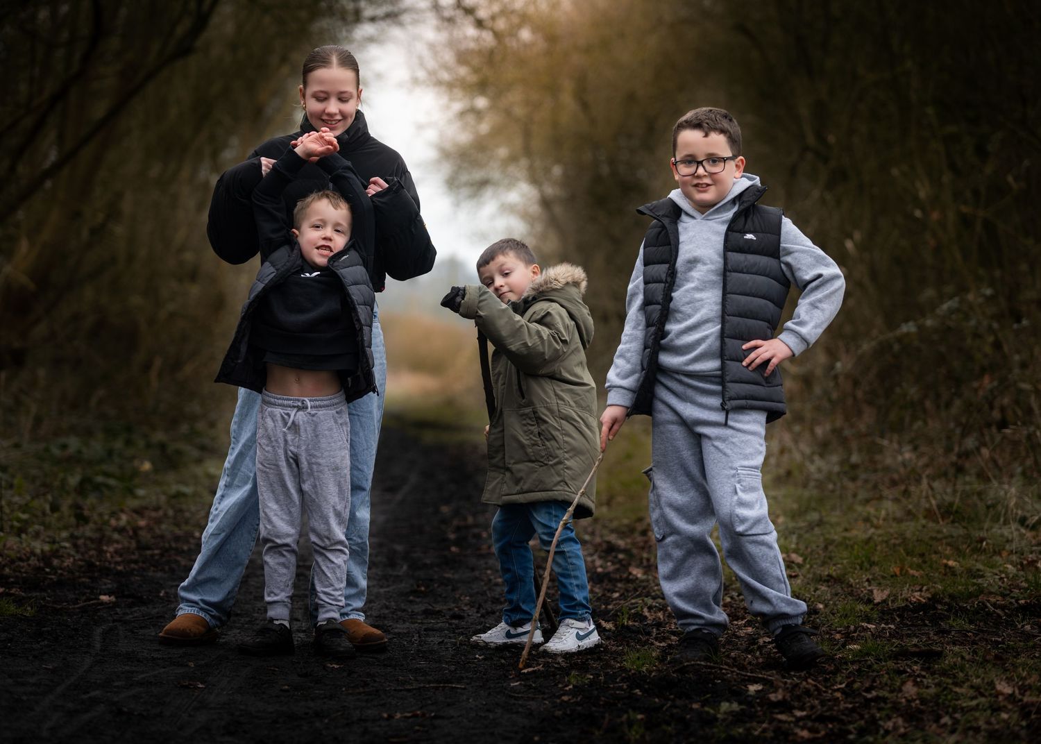 A mother and three children laughing together on a woodland path in autumn.

Keyingham