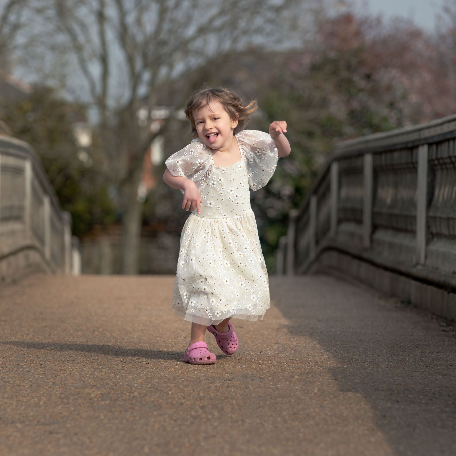 Toddler girl in white dress running on a bridge outdoors.

East Park Hull